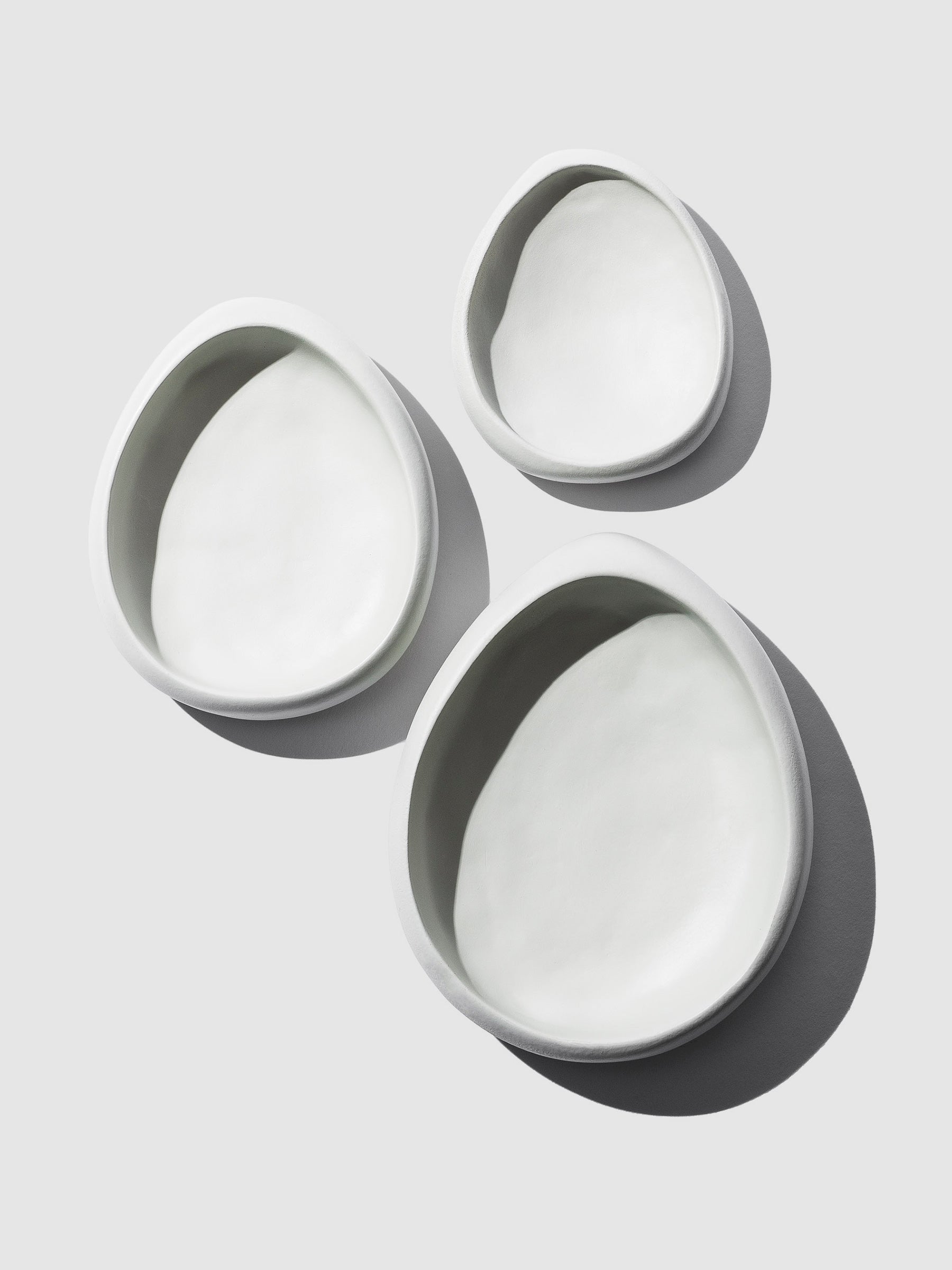 Catch-All Trays | Nested Set of 3 elegantly displayed against a clean neutral background, shadows delicately enhancing their versatile organization in a minimalist setting, creating a chic and functional arrangement.