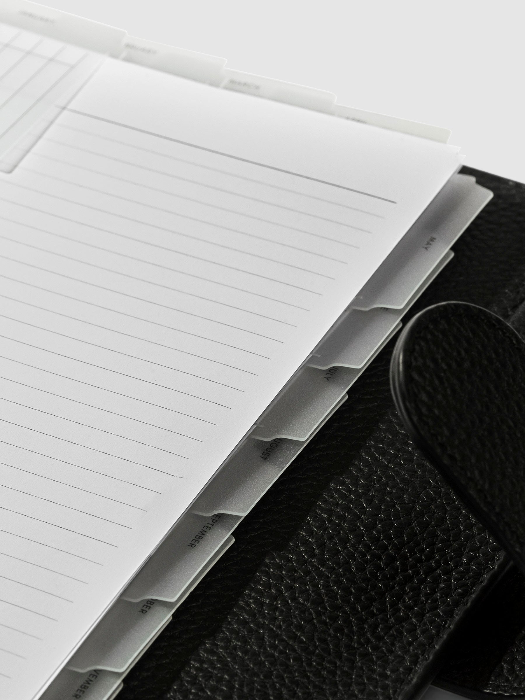 Monthly Clear Index Tab in use inside a leather planner.