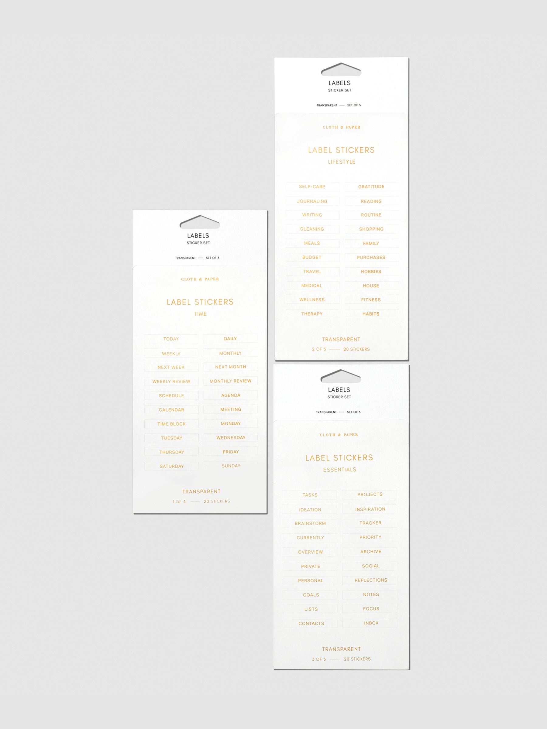 Clear Label Stickers, Gold, Cloth and Paper. 3 sheets of stickers arranged together on a neutral background.