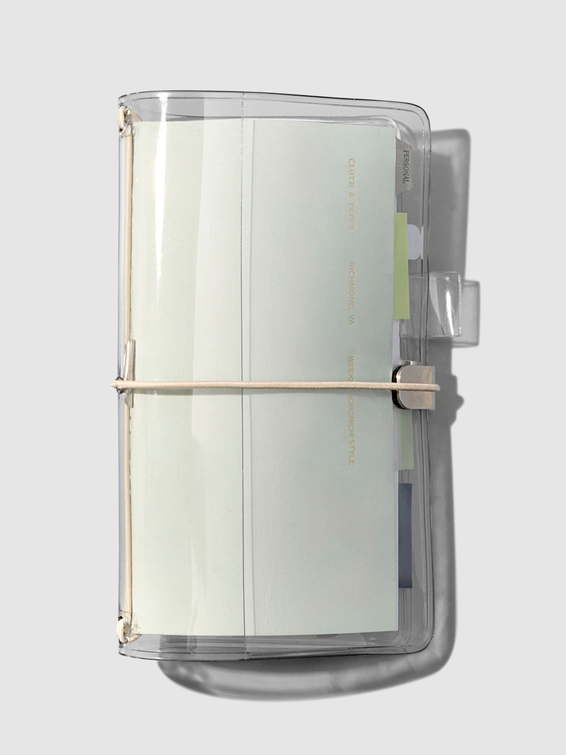 Cover shown closed with a Travel Notebook inside of it on a neutral background.