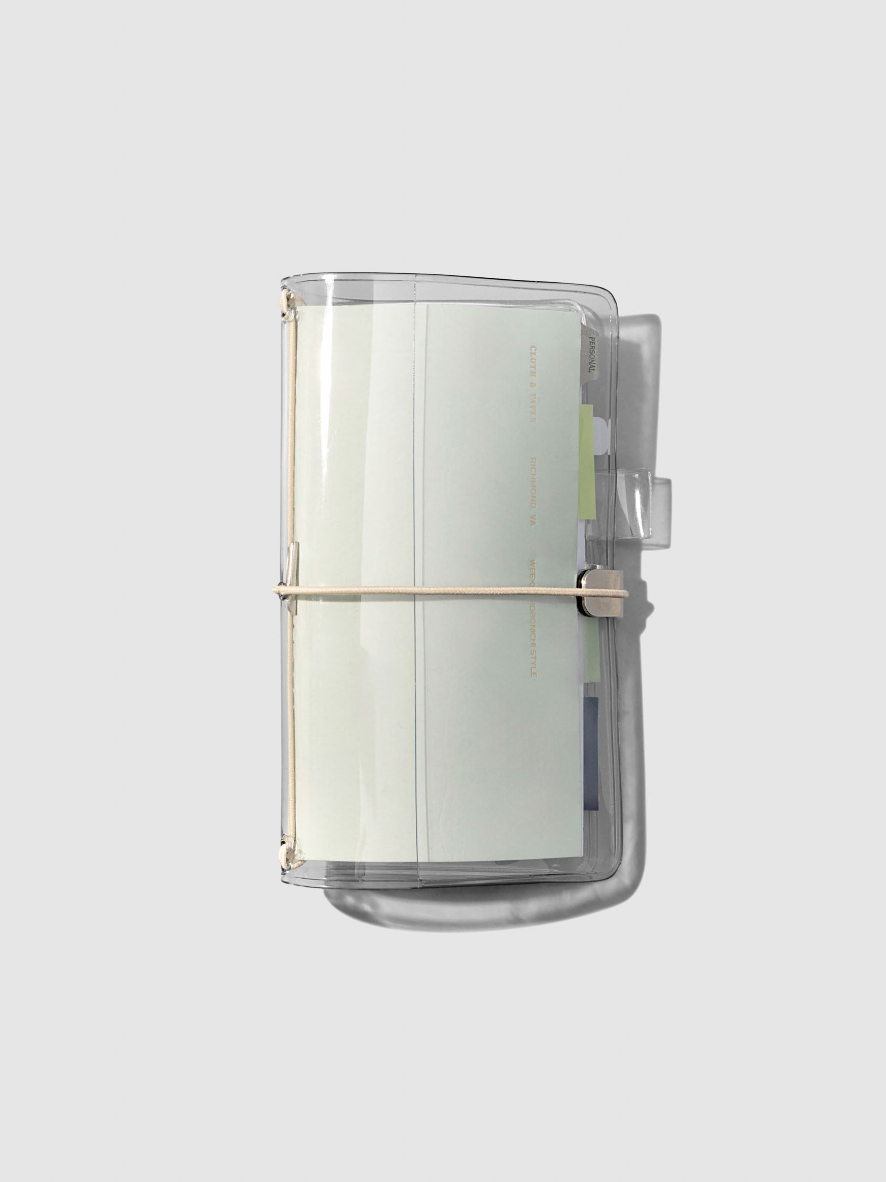 Cover shown closed with a Travel Notebook inside of it on a neutral background.