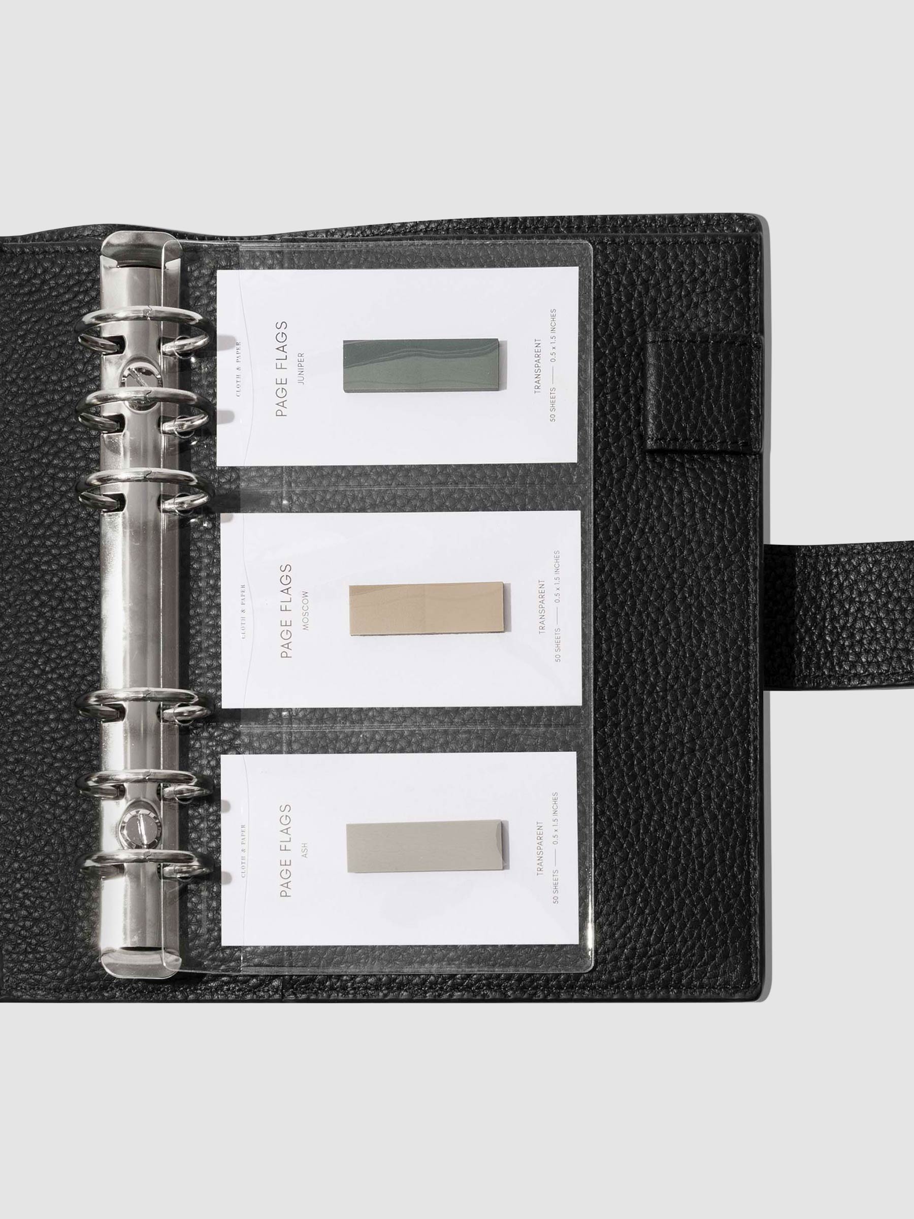 Credit card holders in use inside a black leather folio. Page flags are stored in the open pockets. Size shown is Personal.