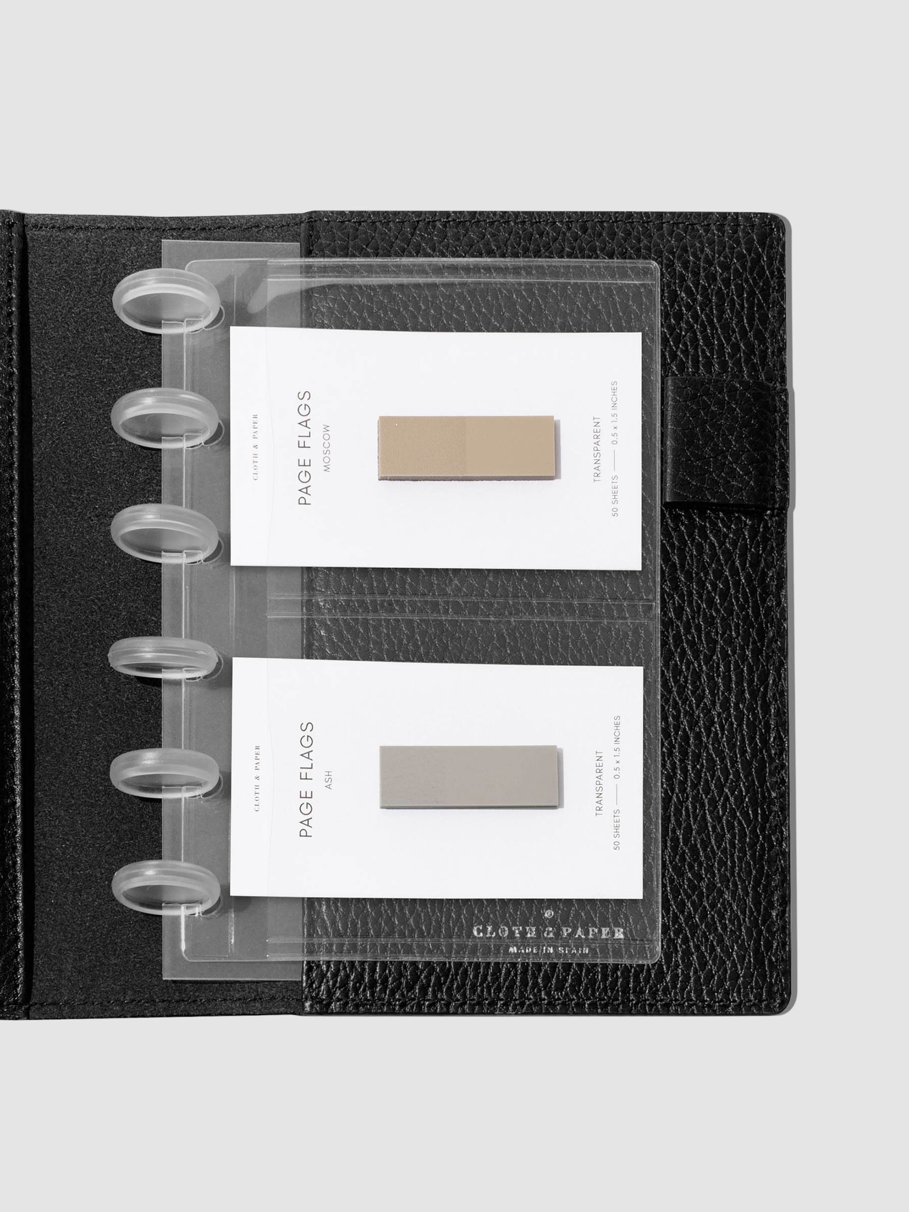 Credit card holders in use inside a black leather folio. Page flags are stored in the open pockets. Size shown is CP Petite.