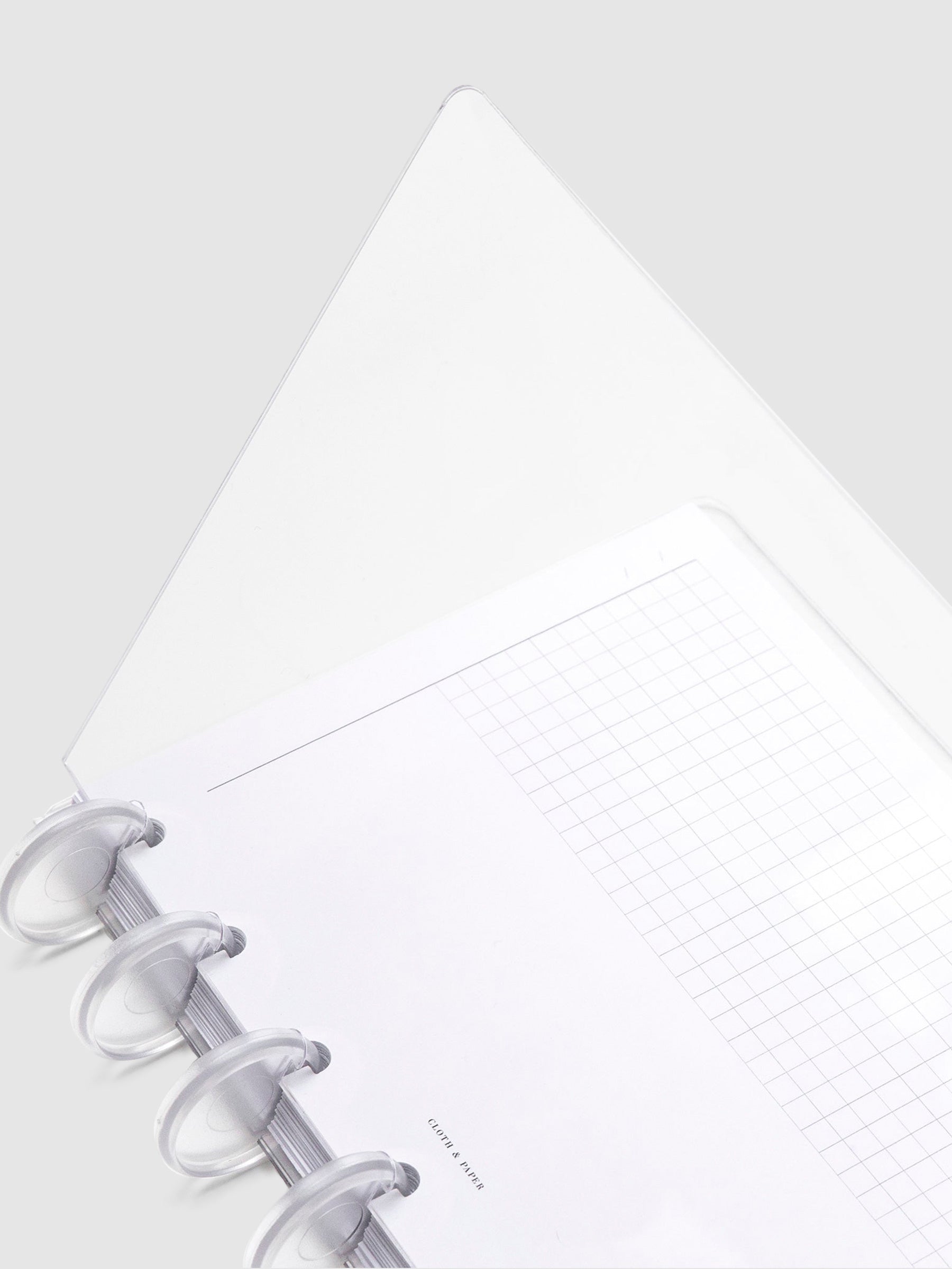 Crystal Clear Discbound Notebook Cover, HP Mini, Cloth and Paper. Close up image of notebook covers in use with clear rings and an insert. The front cover is opened halfway.