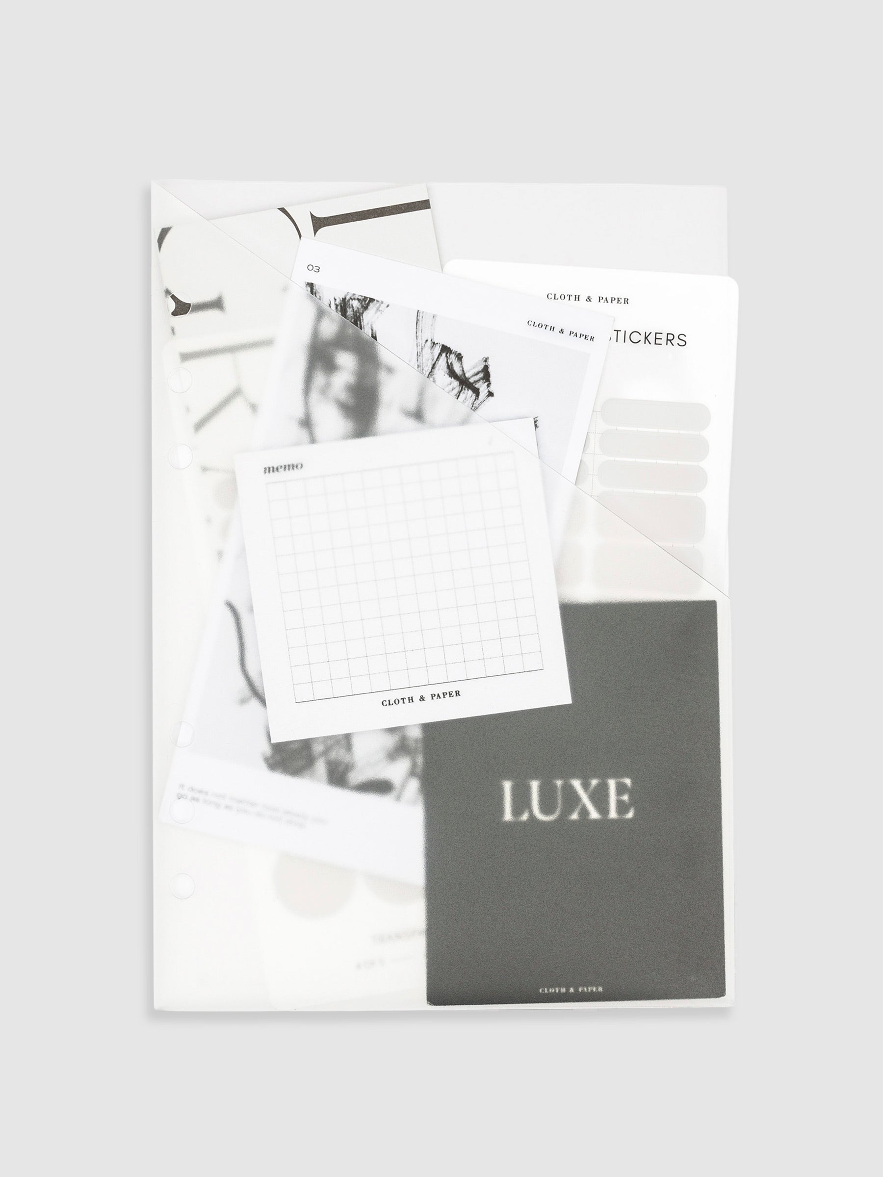 Folder in use on a neutral background. Inside the pocket are several journaling cards, stickers, and sticky notes.