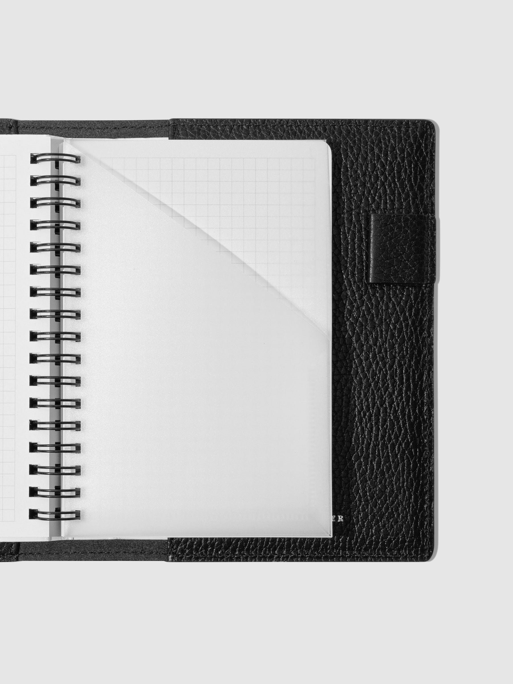 Spiral pocket folder set in use inside a black leather folio.