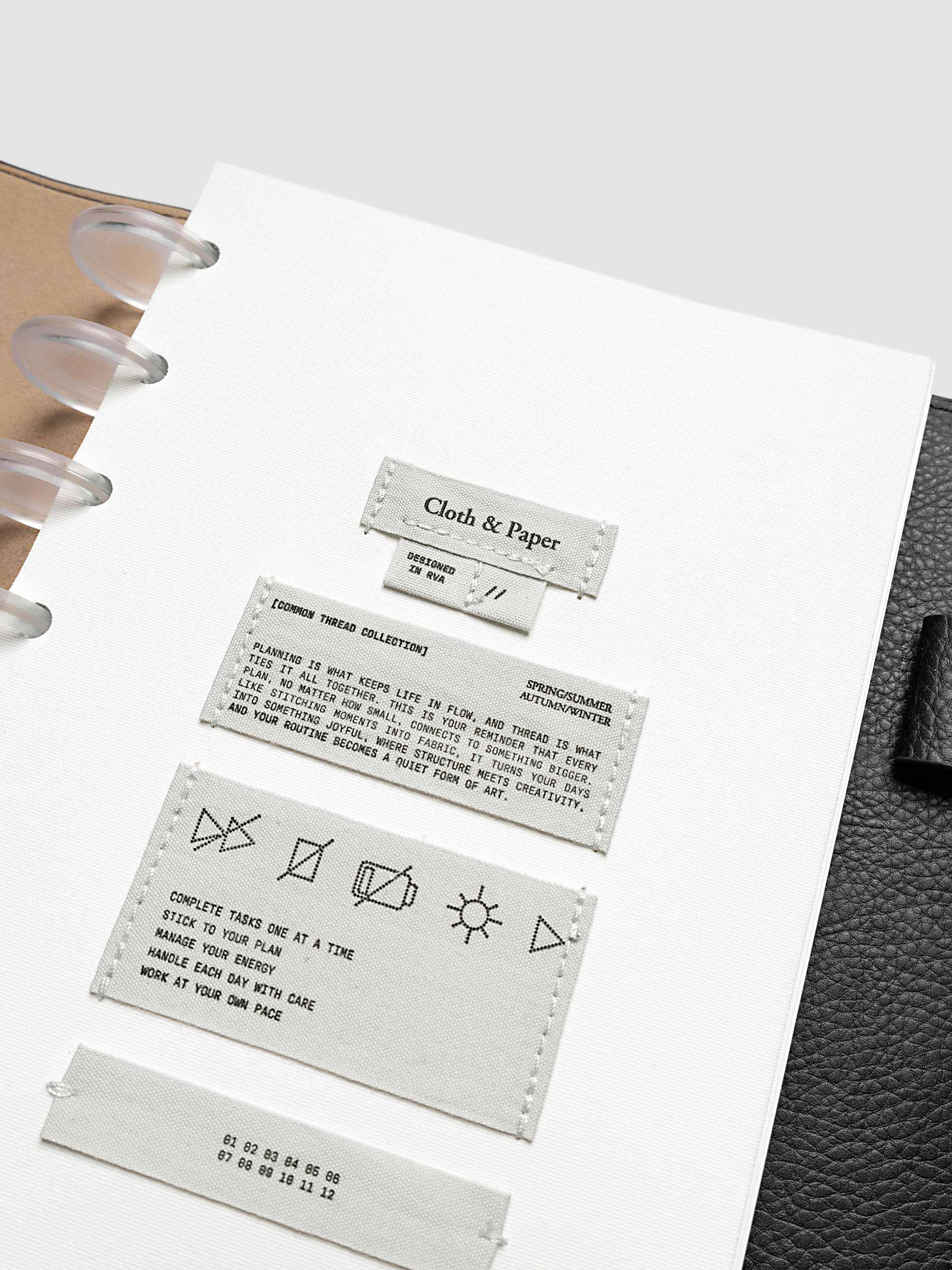 Sewn Tags Planner Dashboard pre-punched for discbound planners in size Half Letter shown in a black leather folio.