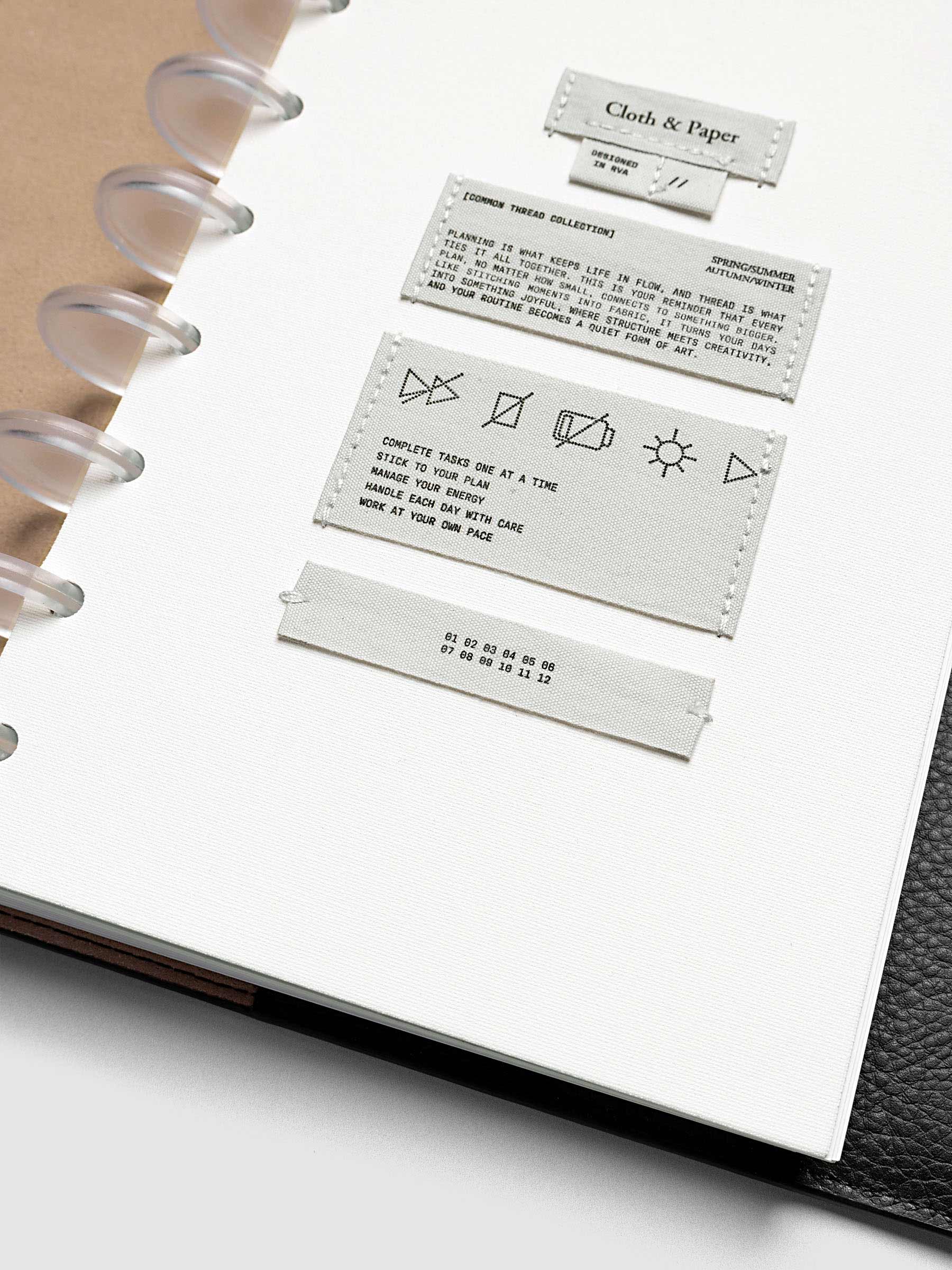 Sewn Tags Planner Dashboard pre-punched for discbound planners in size Half Letter shown in a black leather folio.