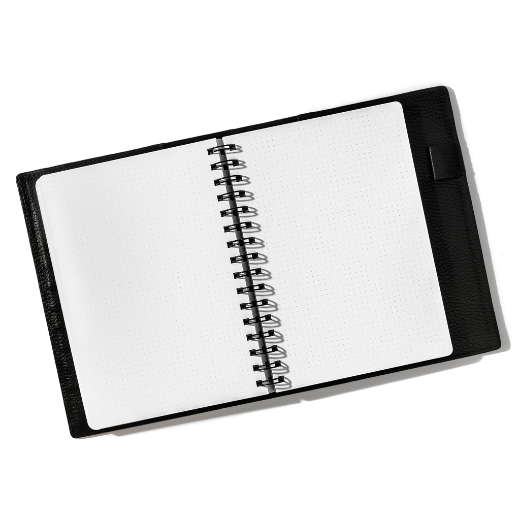 Notebook in use inside a leather folio. Notebook displayed on a white background. Color pictured is Avant Garde. 
