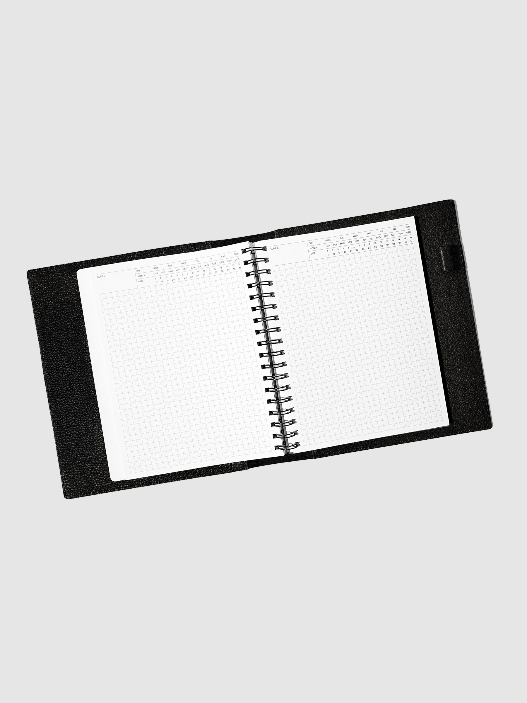Notebook spread open inside a black leather agenda. Design shown is executive notes.