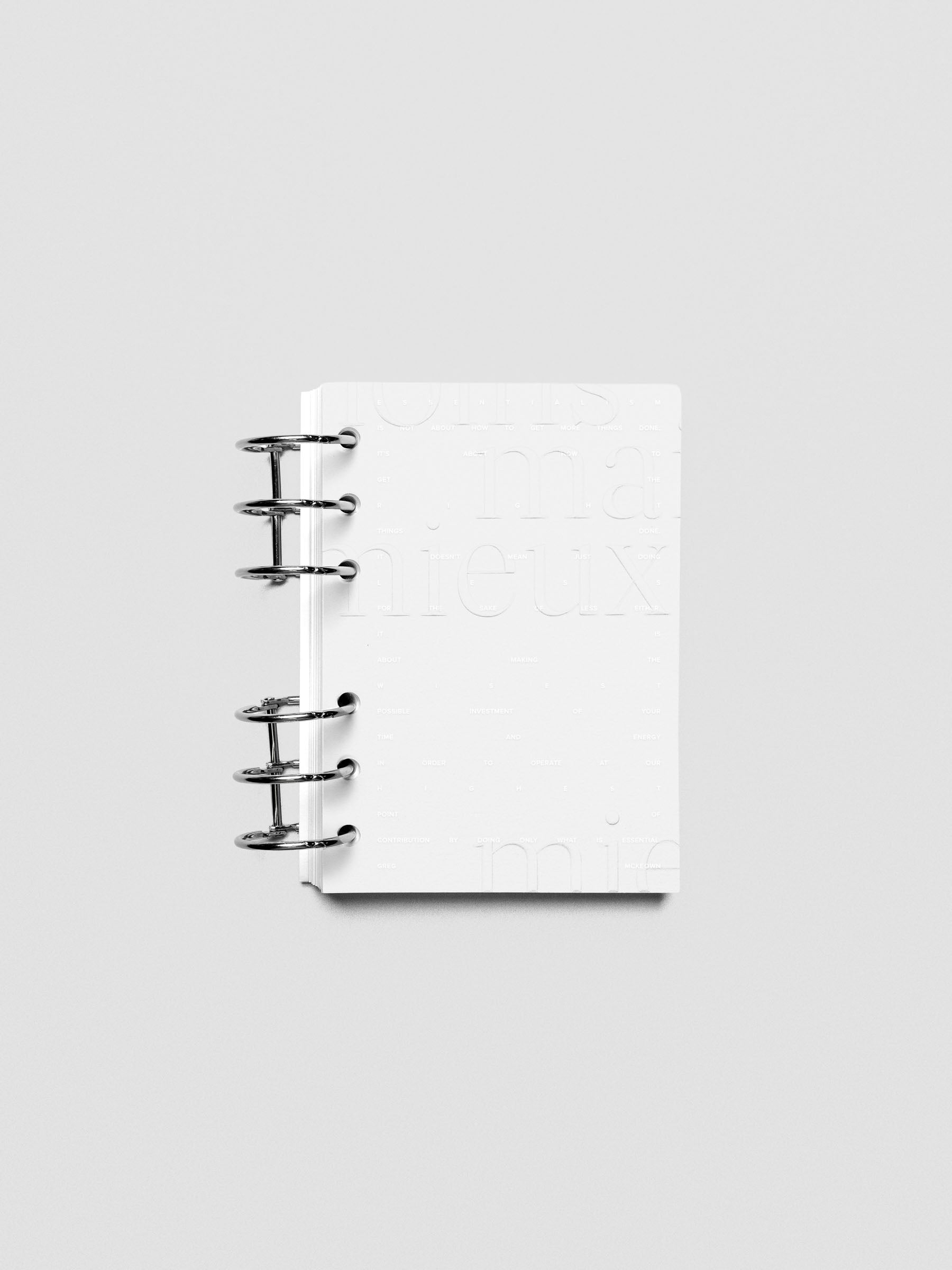 Essentialism Dashboard Duo reading "moins mai mieux" in size A6; shown ringbound.