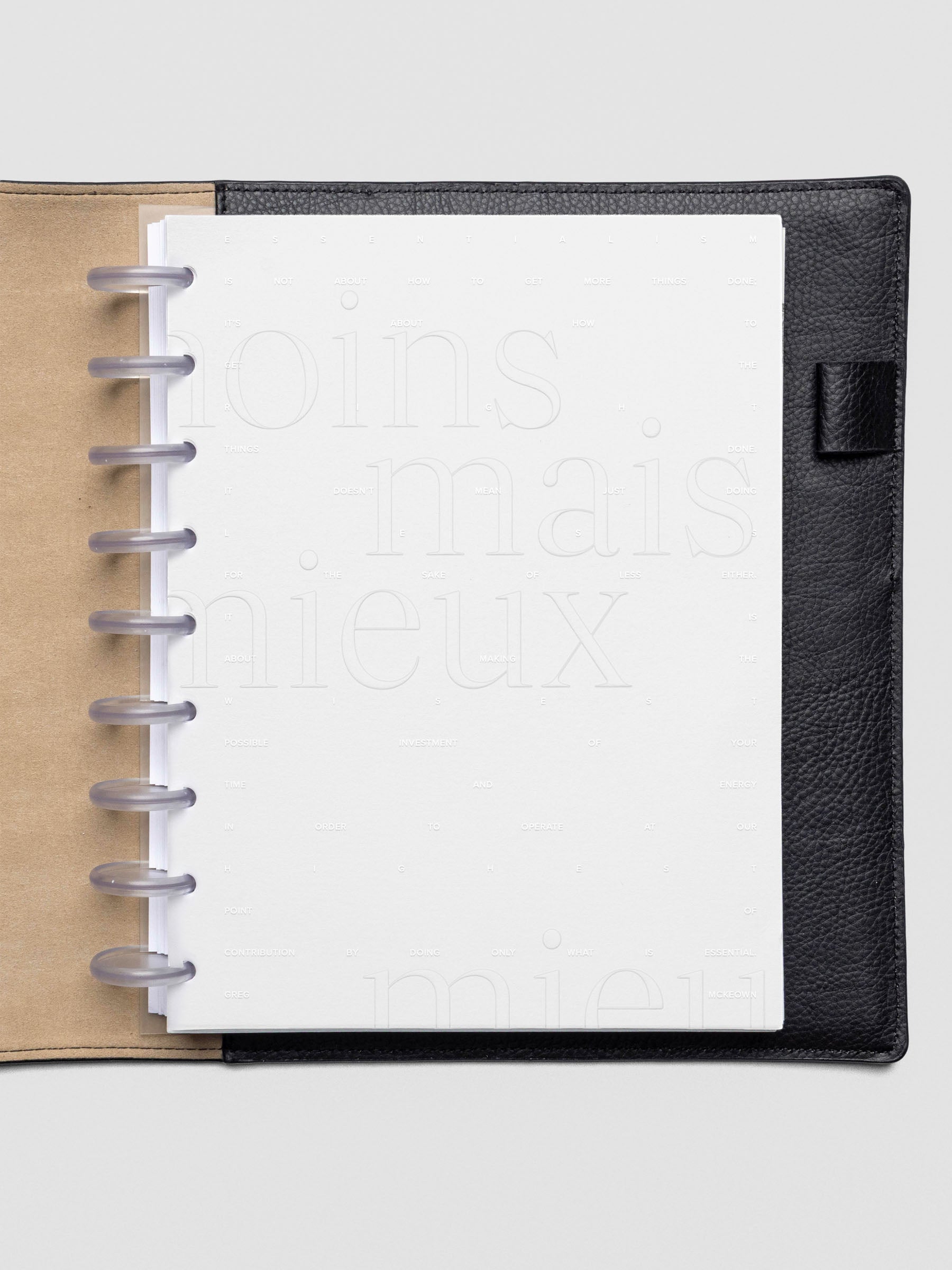 Essentialism Dashboard Duo reading "moins mai mieux" in size HP Classic; shown discbound in a leather folio.