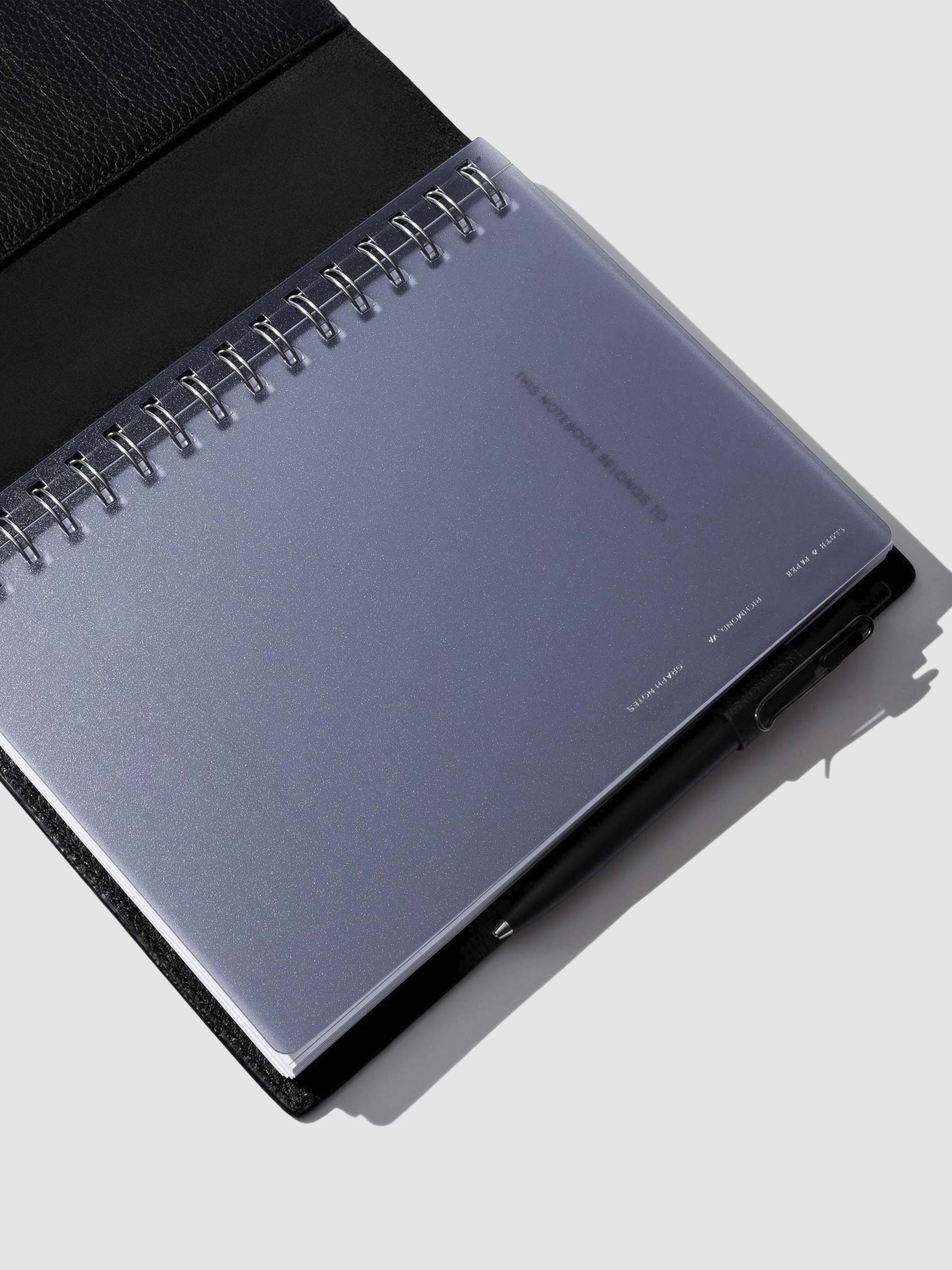 Tinted plastic notebook displayed in a black leather folio.