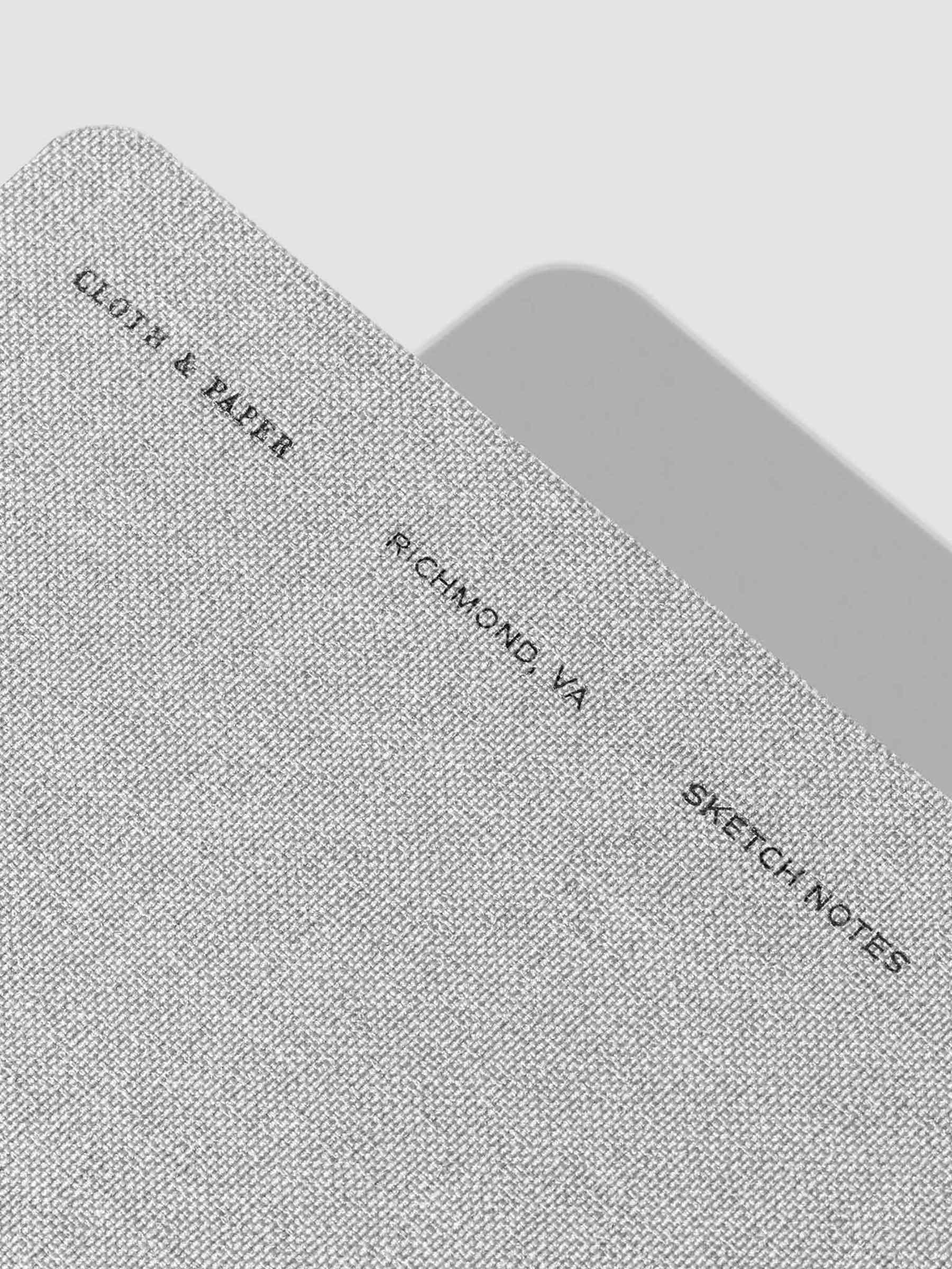 Closeup of linen notebook. Embossed text reads "Cloth & Paper | Richmond, VA | Sketch Notes"