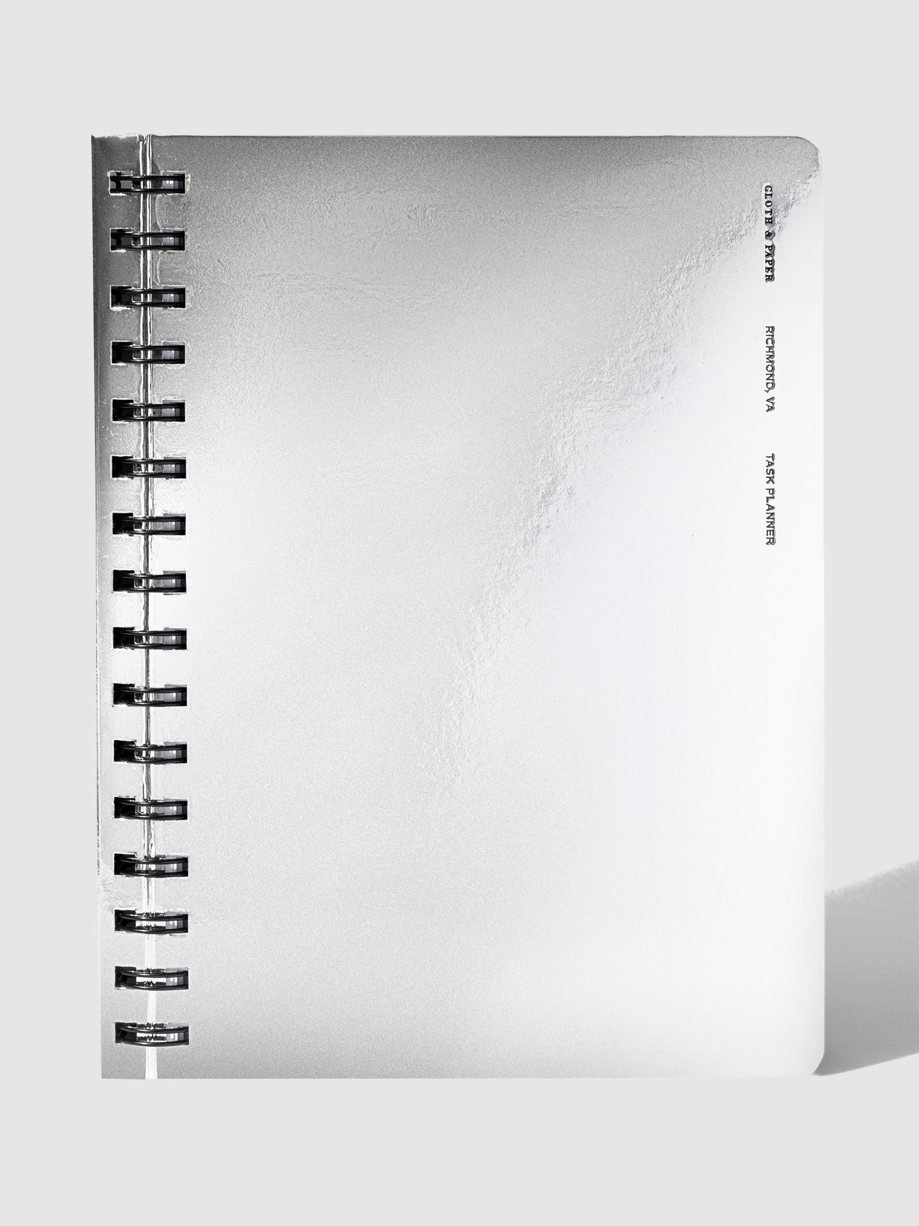 Silver notebook displayed on a neutral background.