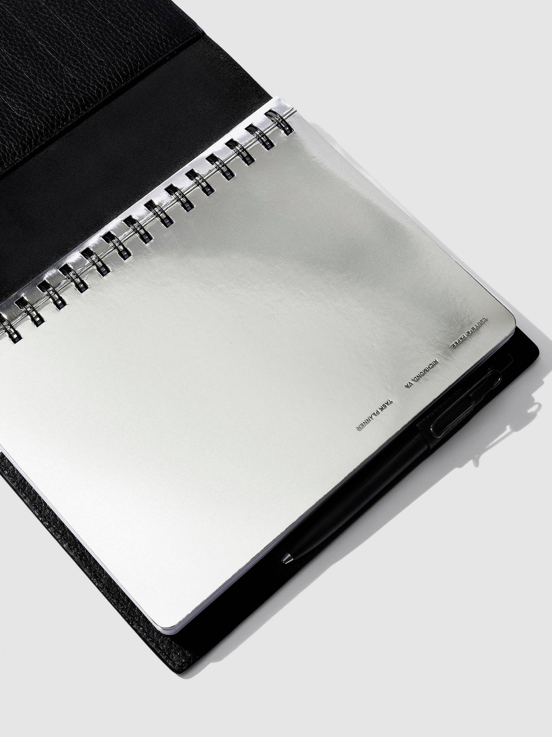 Silver notebook displayed in a black leather folio.
