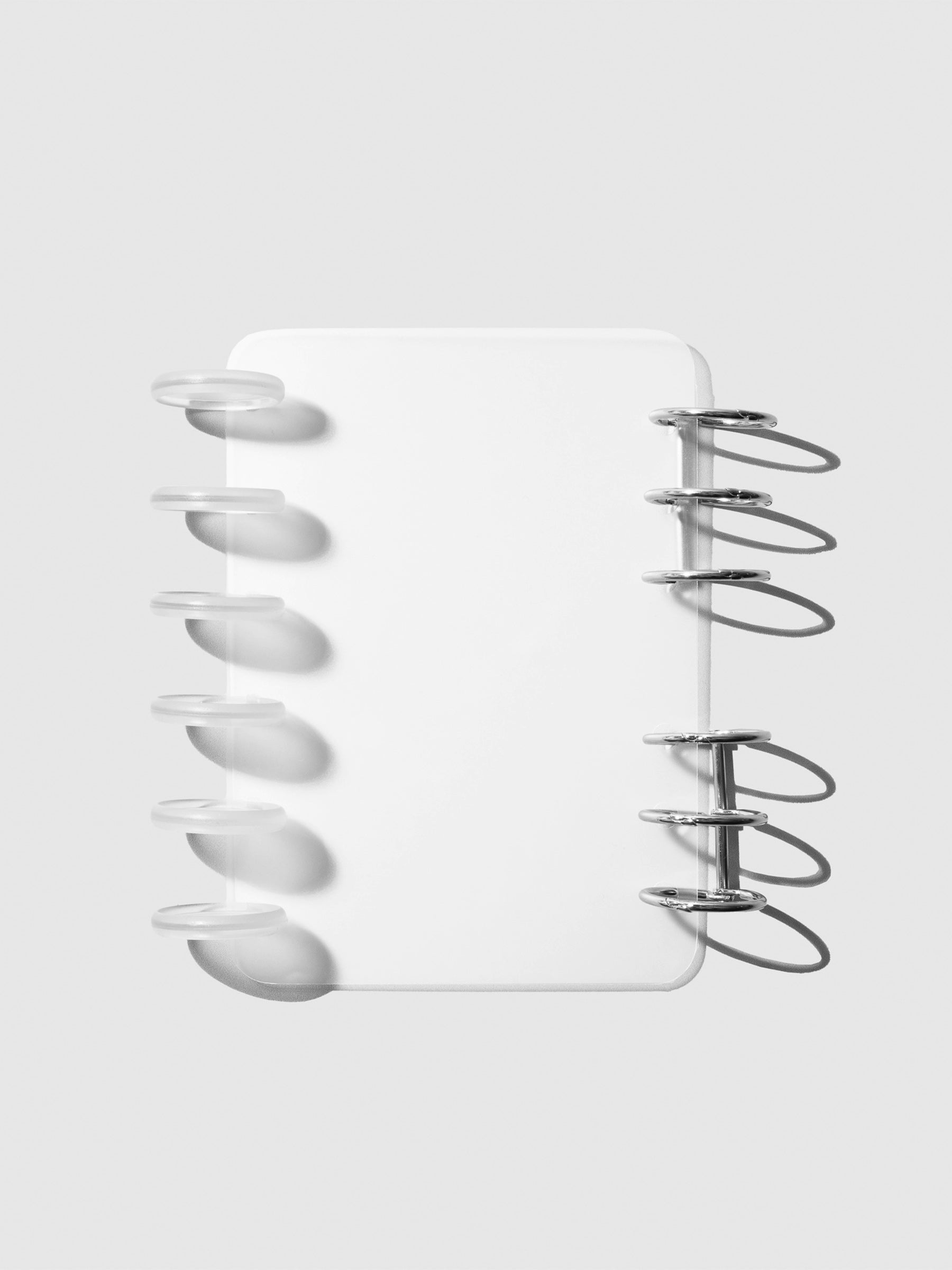 CP Petite/A6 cover displayed on a neutral background. It is shown filled with a set of clear planner discs and black planner rings.