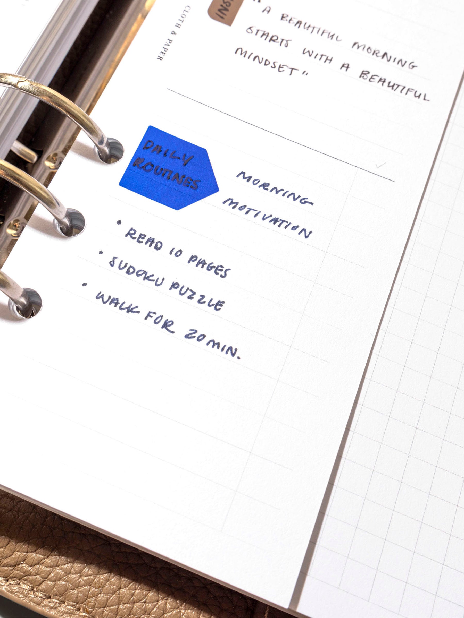 Insert in use inside a leather planner. It has sample text filled out and several stickers decorate different sections of the insert.