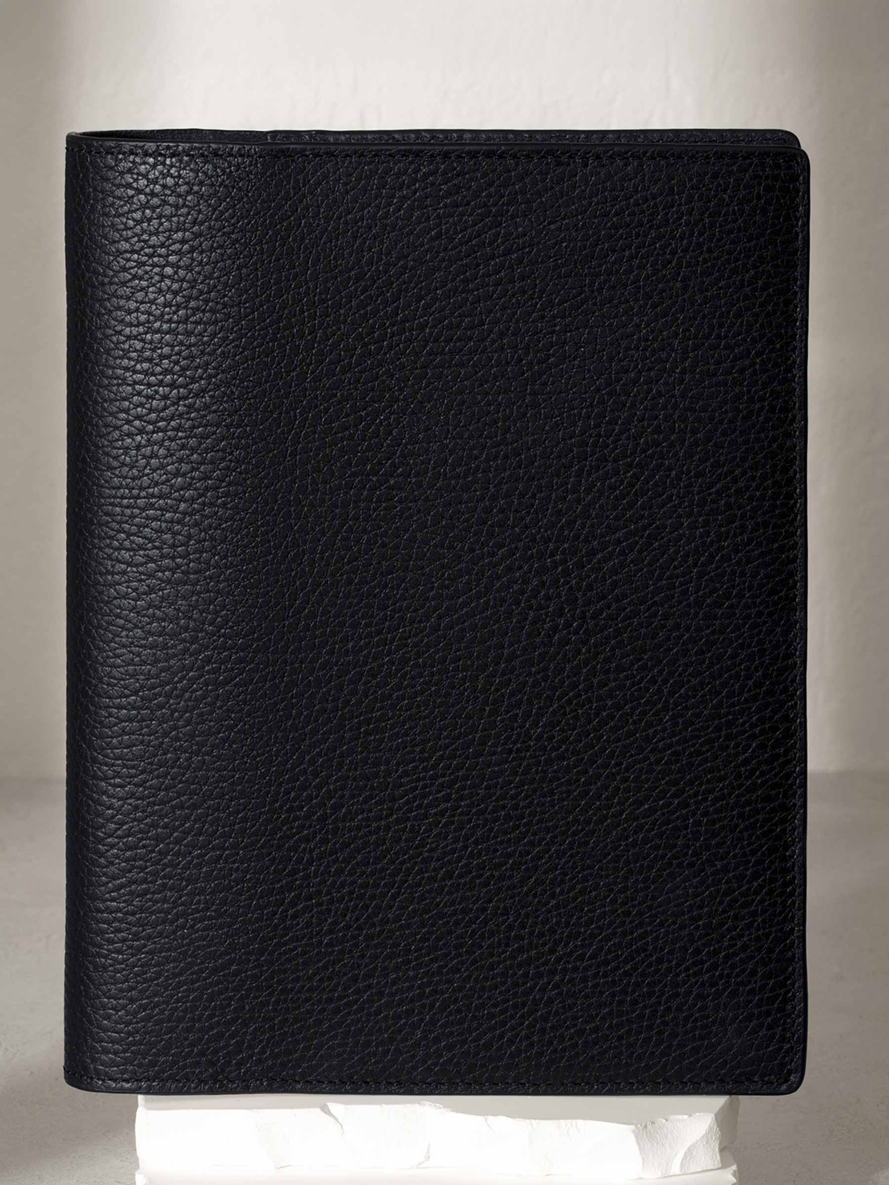 Heirloom Leather Folio, Large, Cloth and Paper. Padrillo folio displayed on a white stone pedestal. The background is a natural textured off-white material, and a spotlight behind the folio highlights its placement.