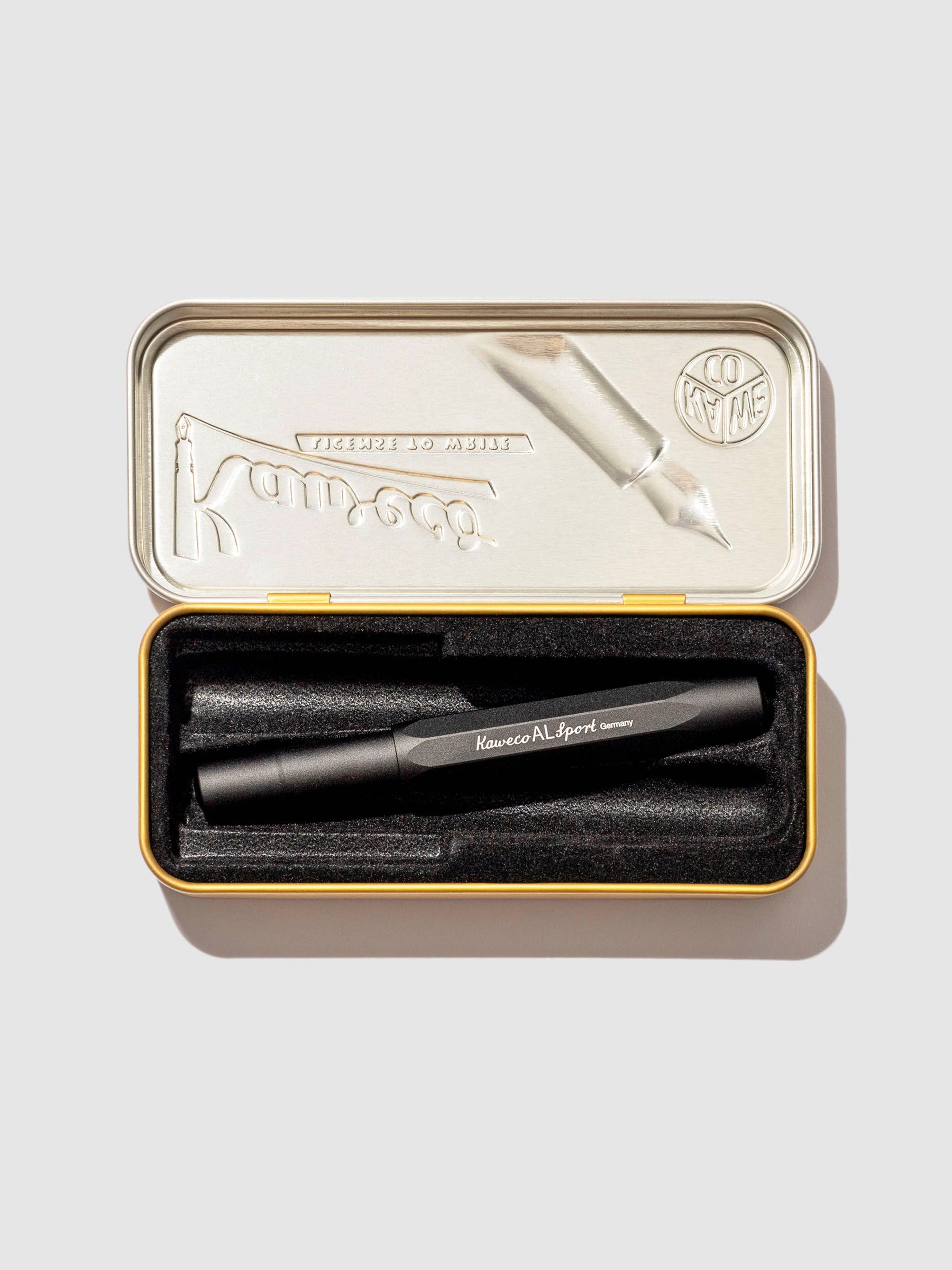 Pen displayed in its tin case on a neutral background.