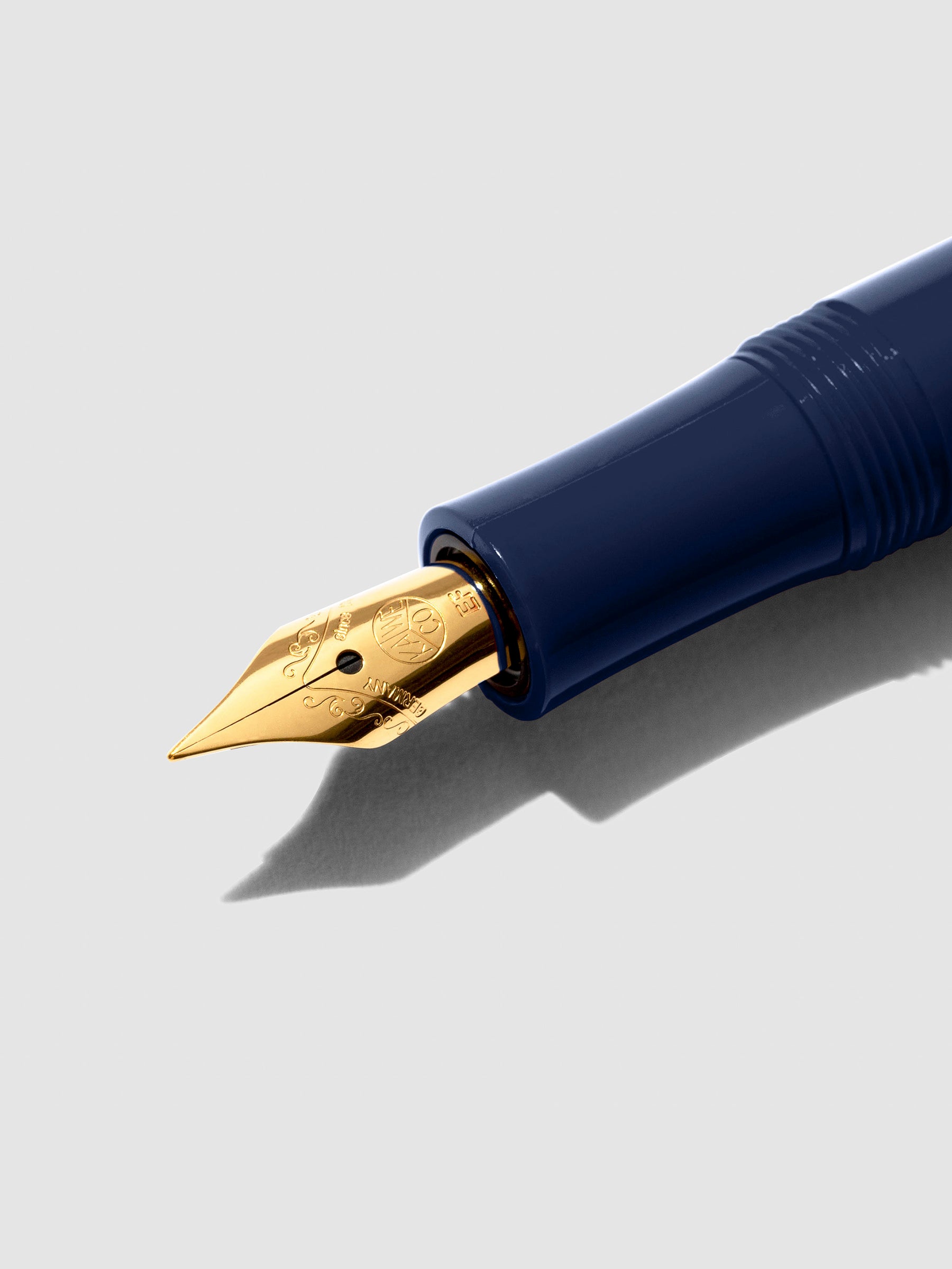 Closeup of Navy pen nib on a neutral background.