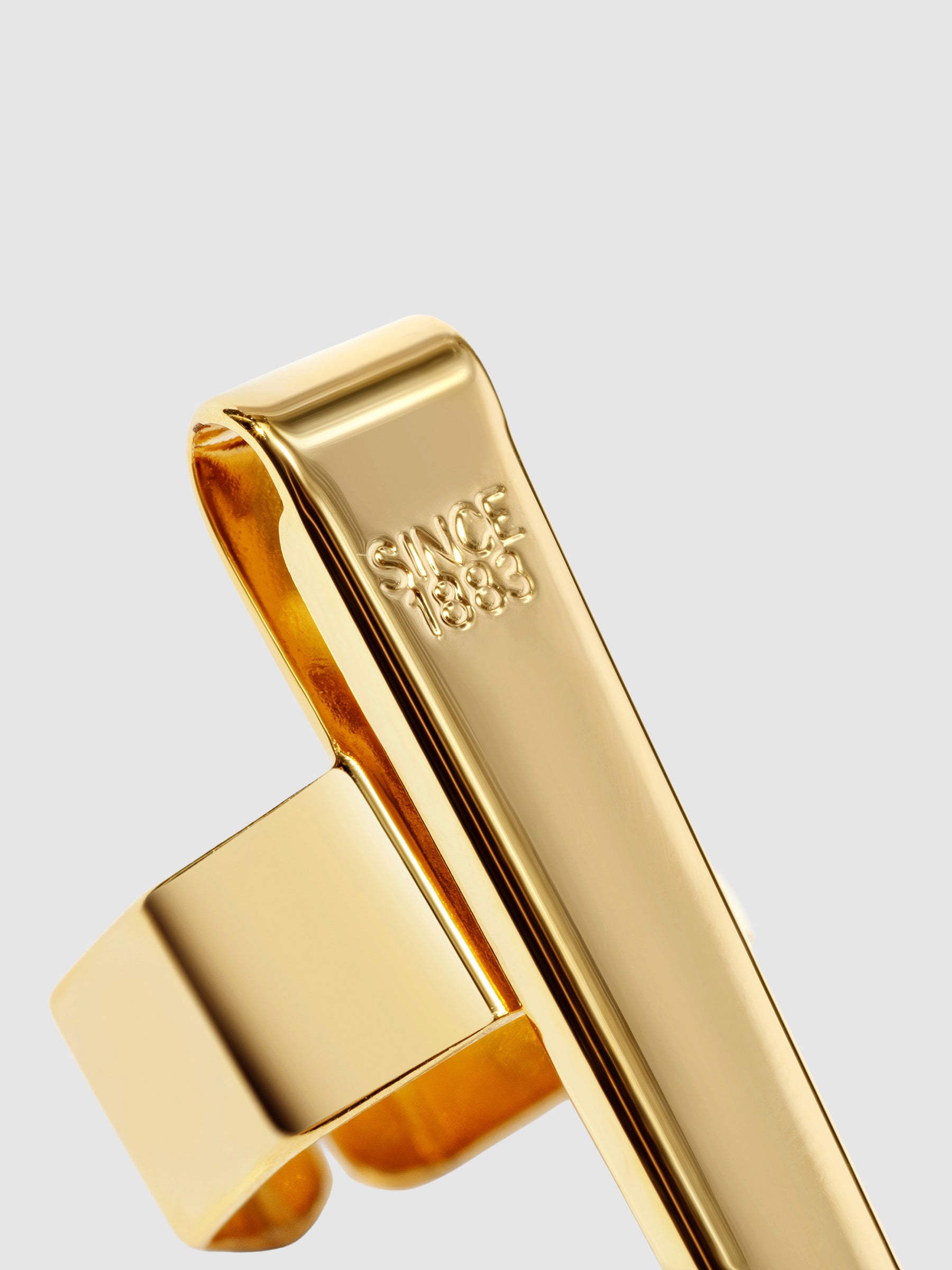 Standard gold clip displayed on a neutral background. Closeup of text reads "Since 1883"