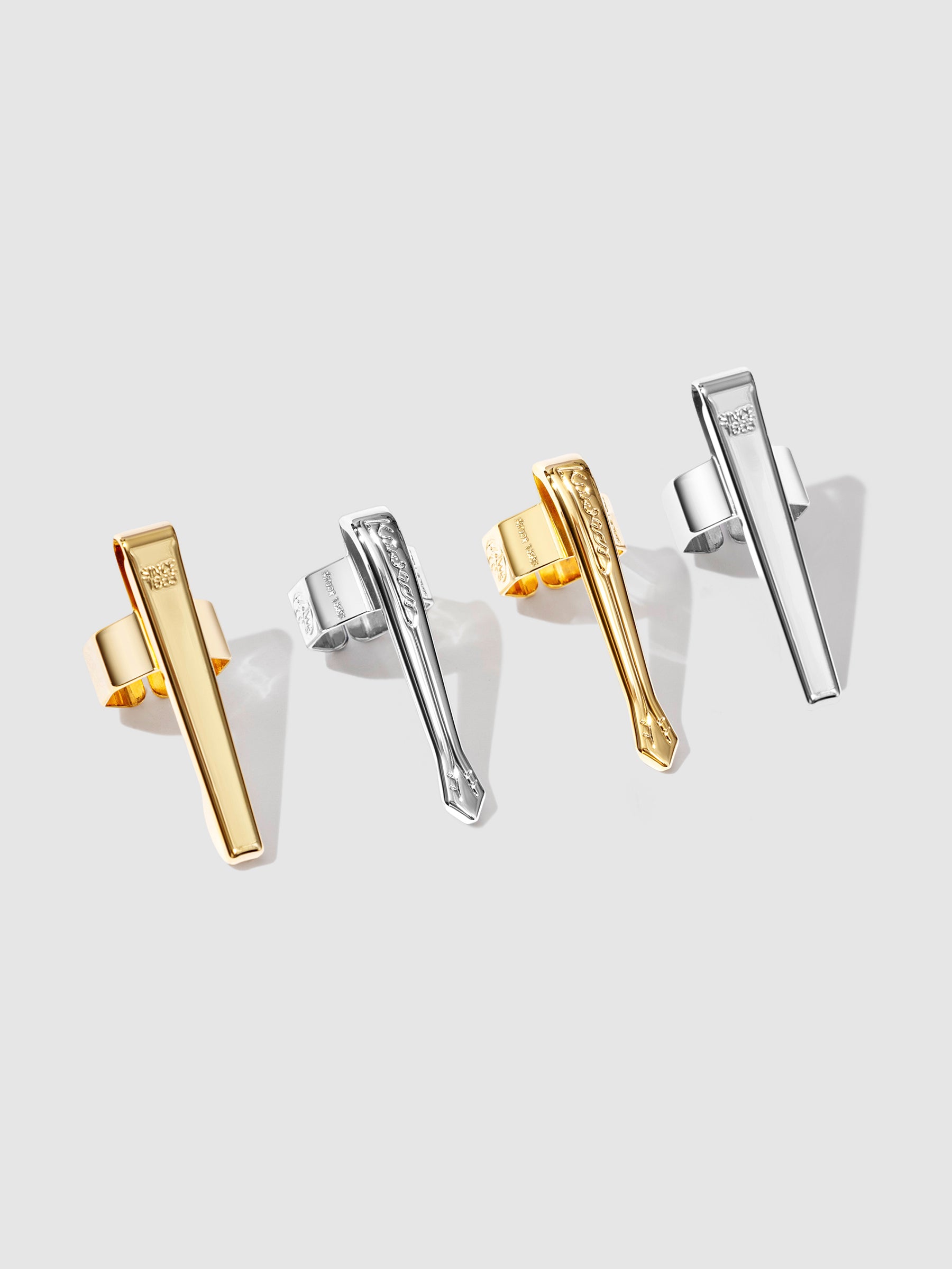 Kaweco Sport Pen Clip, Cloth and Paper. Four clips - two gold, and two chrome - are arranged on a neutral background.