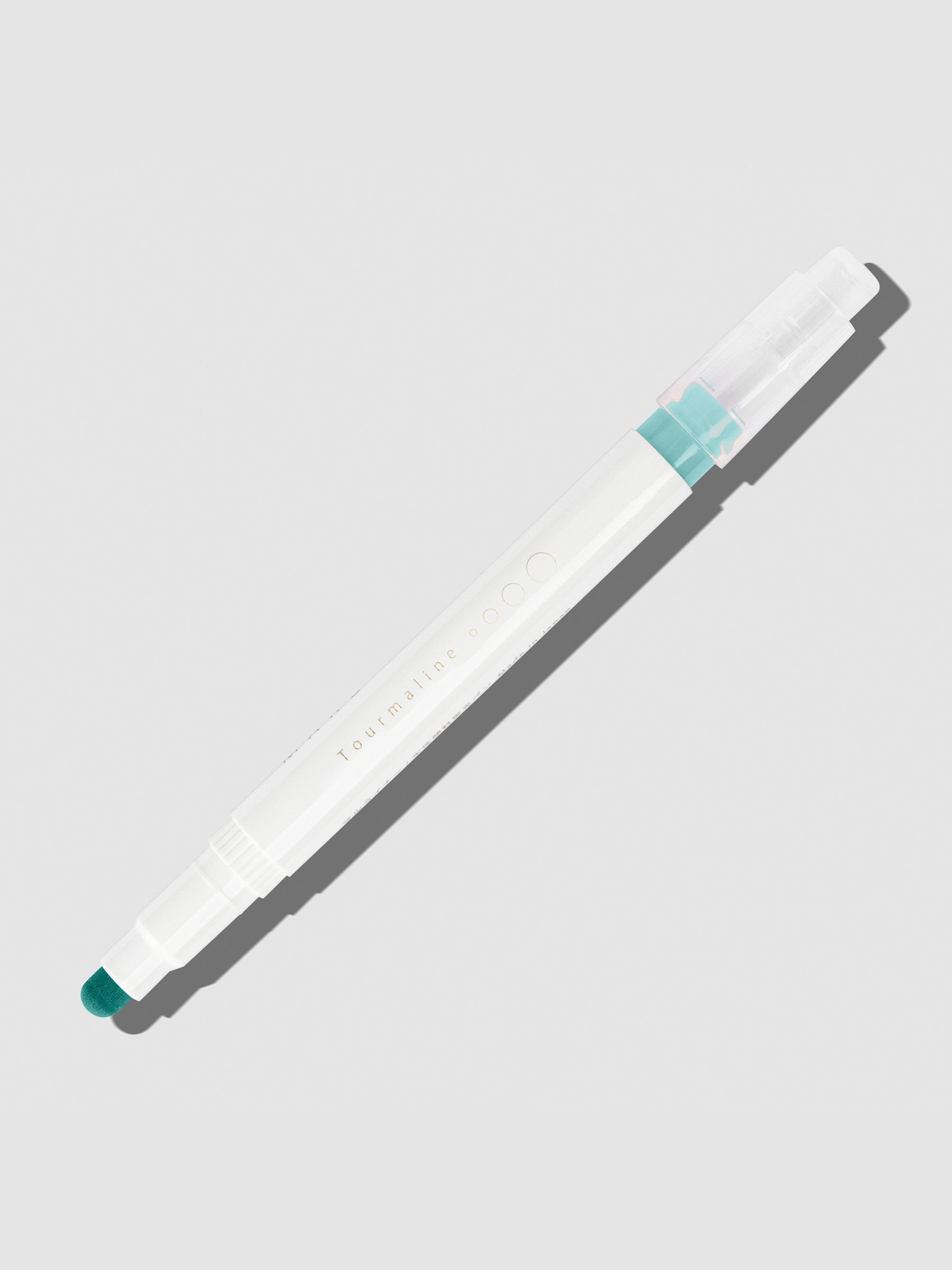 Tourmaline highlighter with tip exposed and cap posted to the end of its barrel on a neutral background.