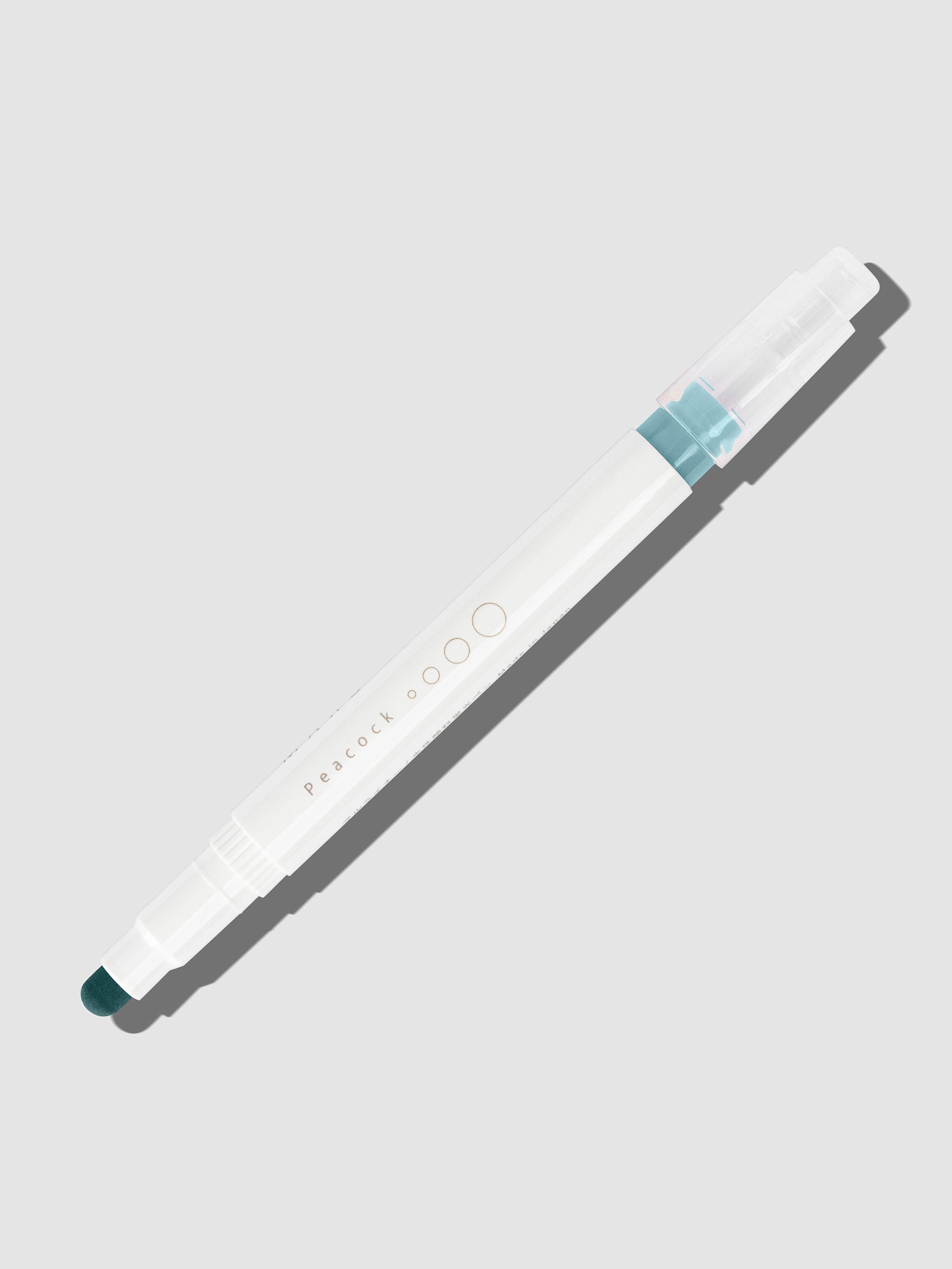 Peacock highlighter with tip exposed and cap posted to the end of its barrel on a neutral background.