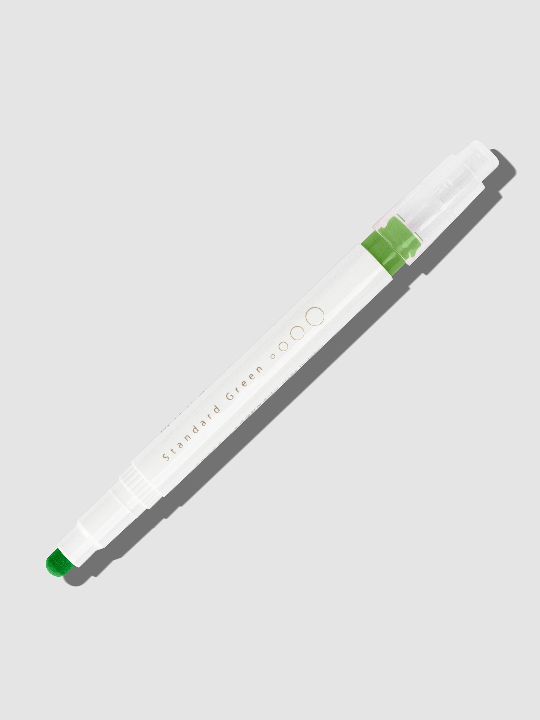 Standard Green highlighter with tip exposed and cap posted to the end of its barrel on a neutral background.