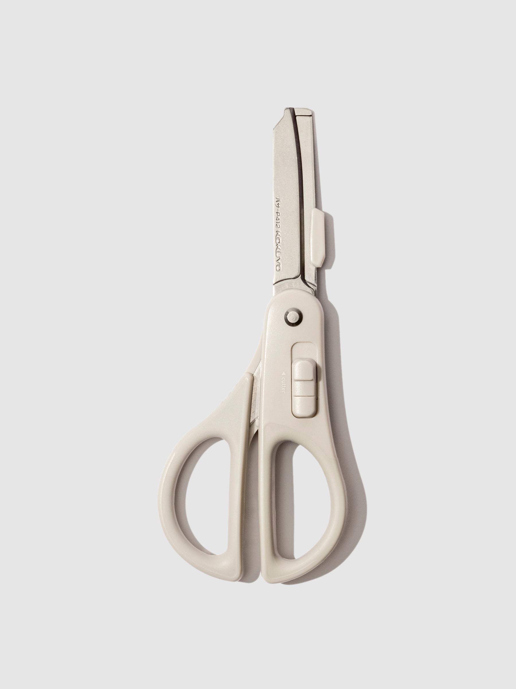 Scissors with blade exposed displayed on a neutral background.