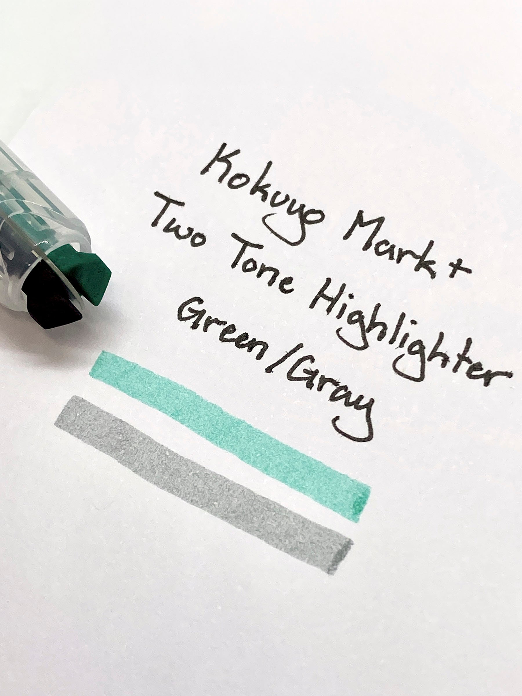 Close up on the highlighter's dual chisel tips resting on a sheet with a writing sample.