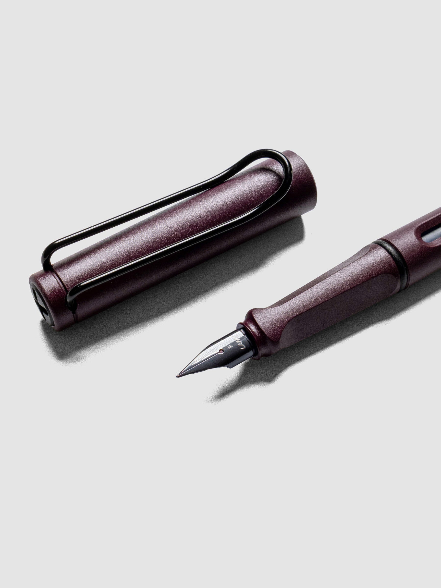 Close up of LAMY Safari Fountain Pen in the color Scarlett with Fine nib shown diagonally with the cap off.