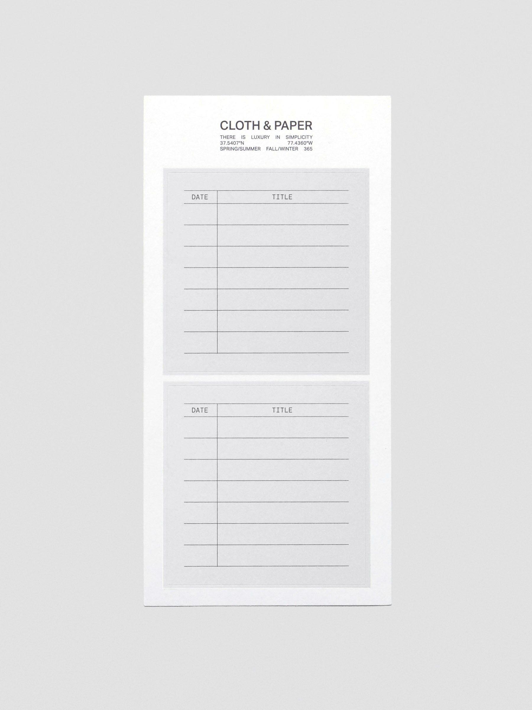 A sheet of two grey, square labels with headers for date and title.