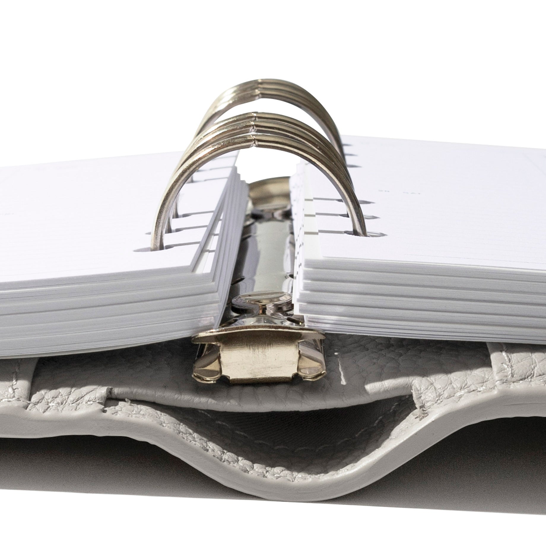 A Foundations Leather 6-Ring Agenda in color Ash is opened showing the rings with planner inserts layered inside.