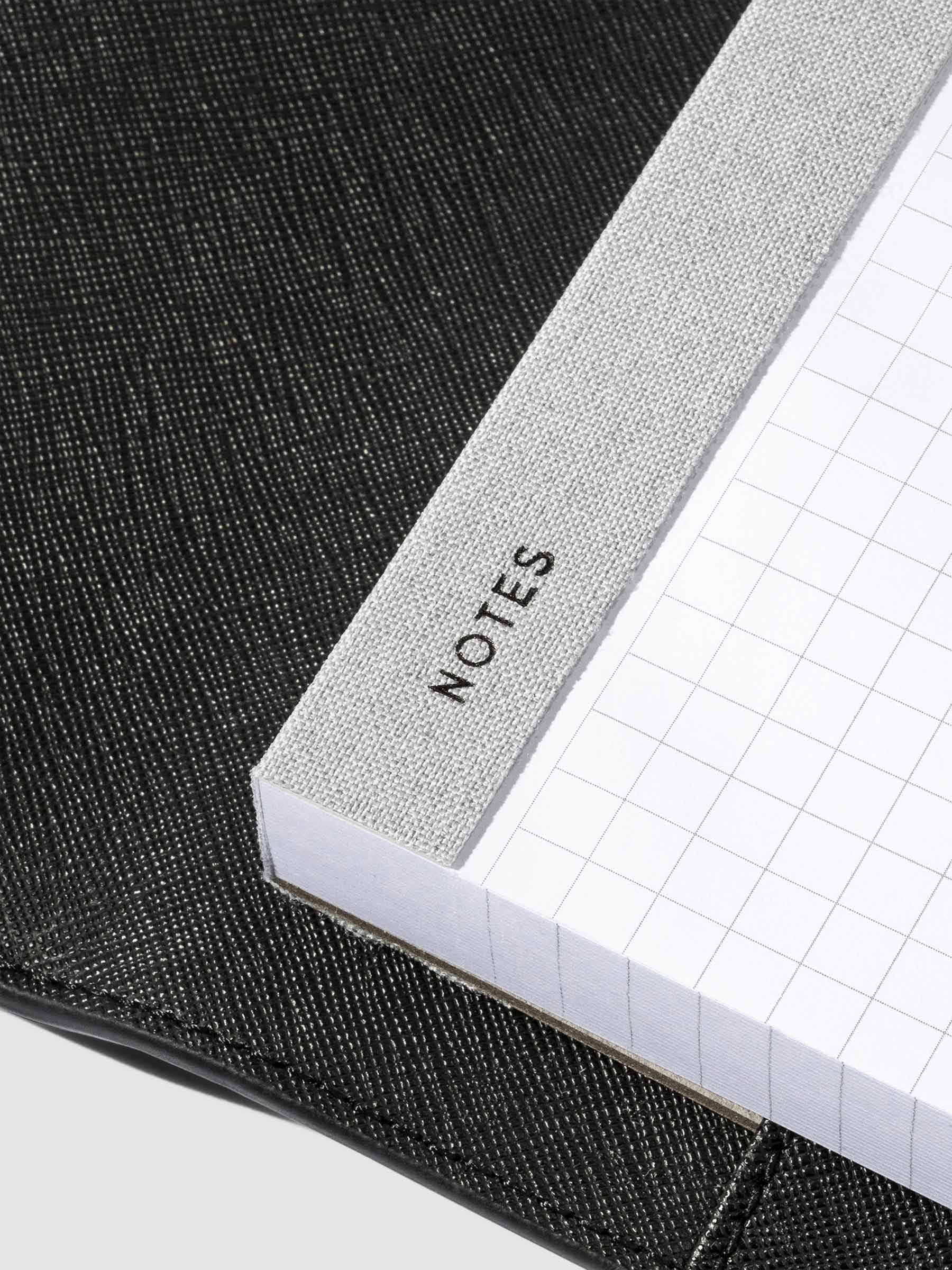 Closeup of "Notes" text printed into the fabric spine of the notepad.