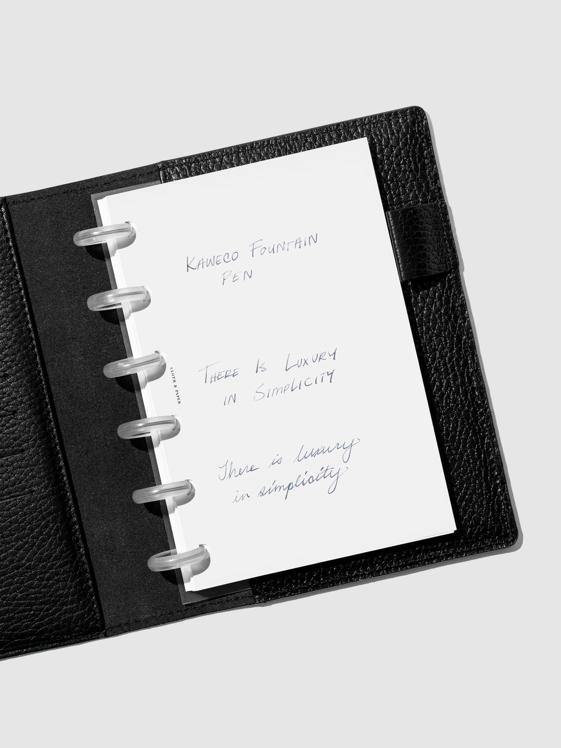 Writing sample shown in a black leather folio.