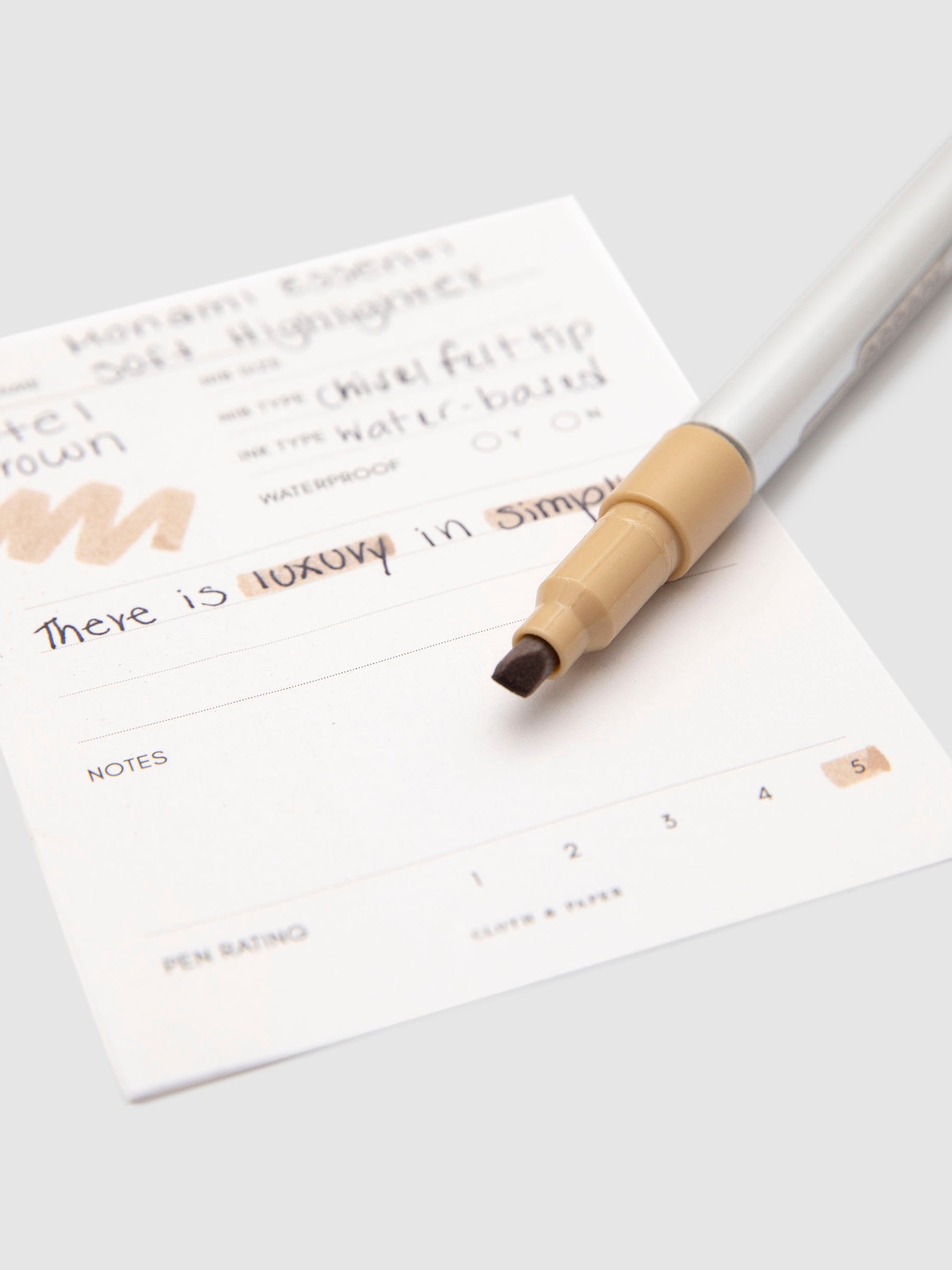 Monami Essenti Soft Highlighter, Pastel Brown, Cloth and Paper. Close up on chisel tip of highlighter.