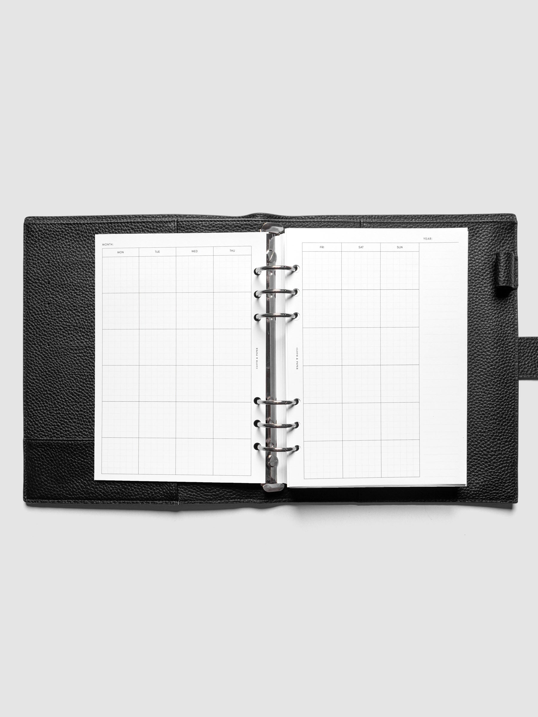 A5 Monthly Graph Planner Inserts ringbound in a black leather agenda.