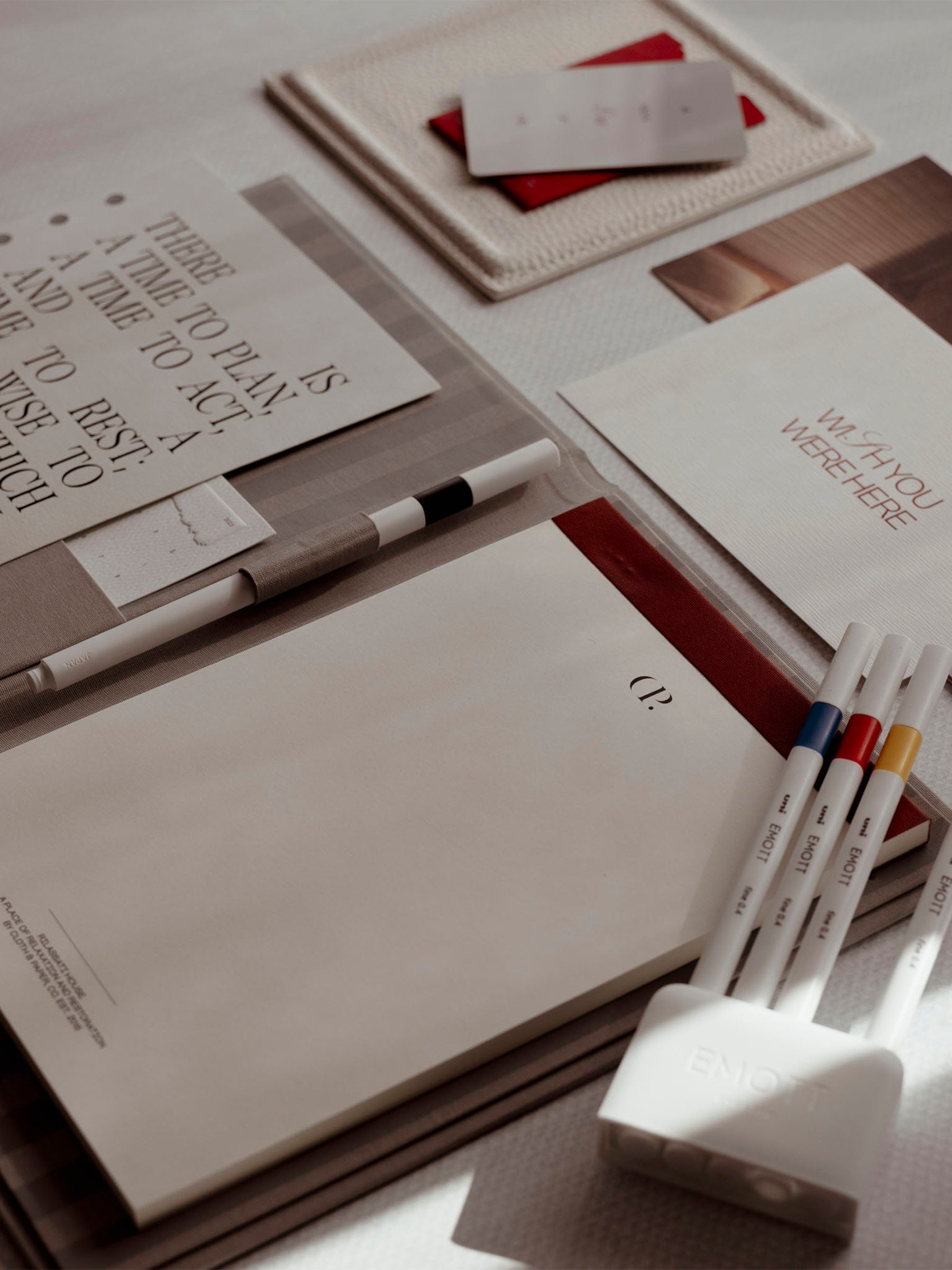 Notepad Folio displayed on a white table. A planner dashboard, notepad folio refill, pens, trinket tray, letter set, and Uni Emott pens are displayed on and around the Notepad Folio.