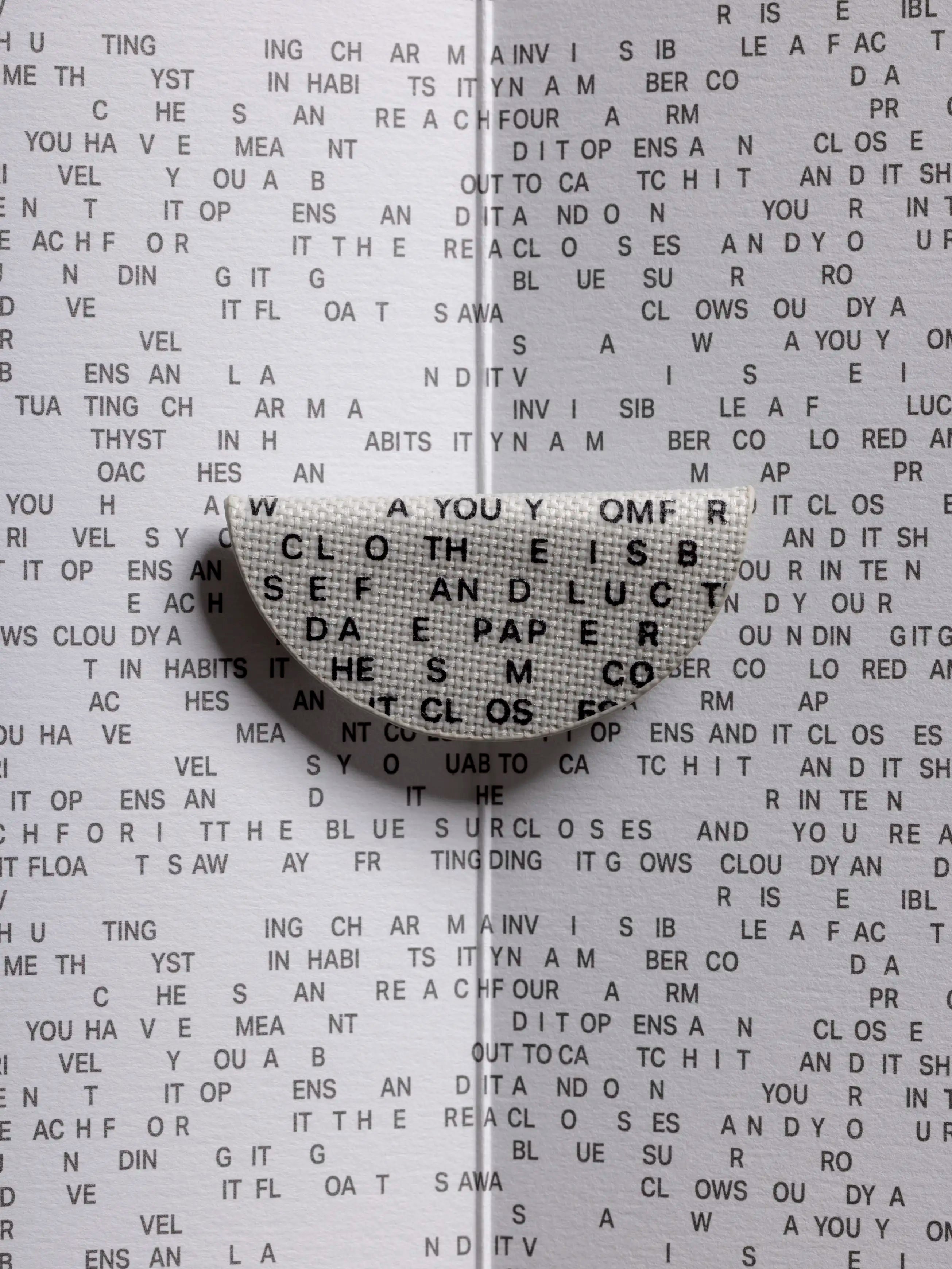 A Magnetic Bookmark with letters against a background of various letters.
