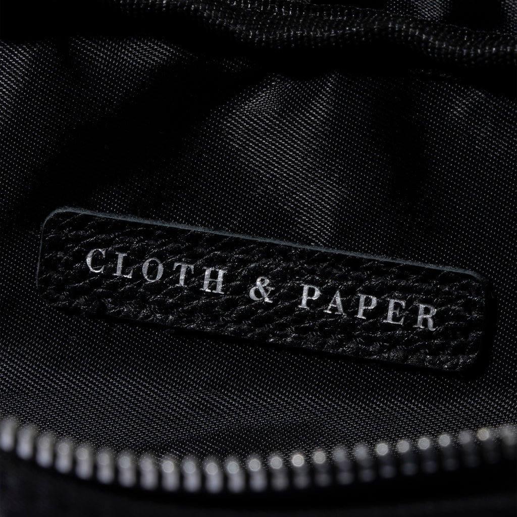Closeup of Cloth and Paper logo inside of pencil pouch. Color featured is black.