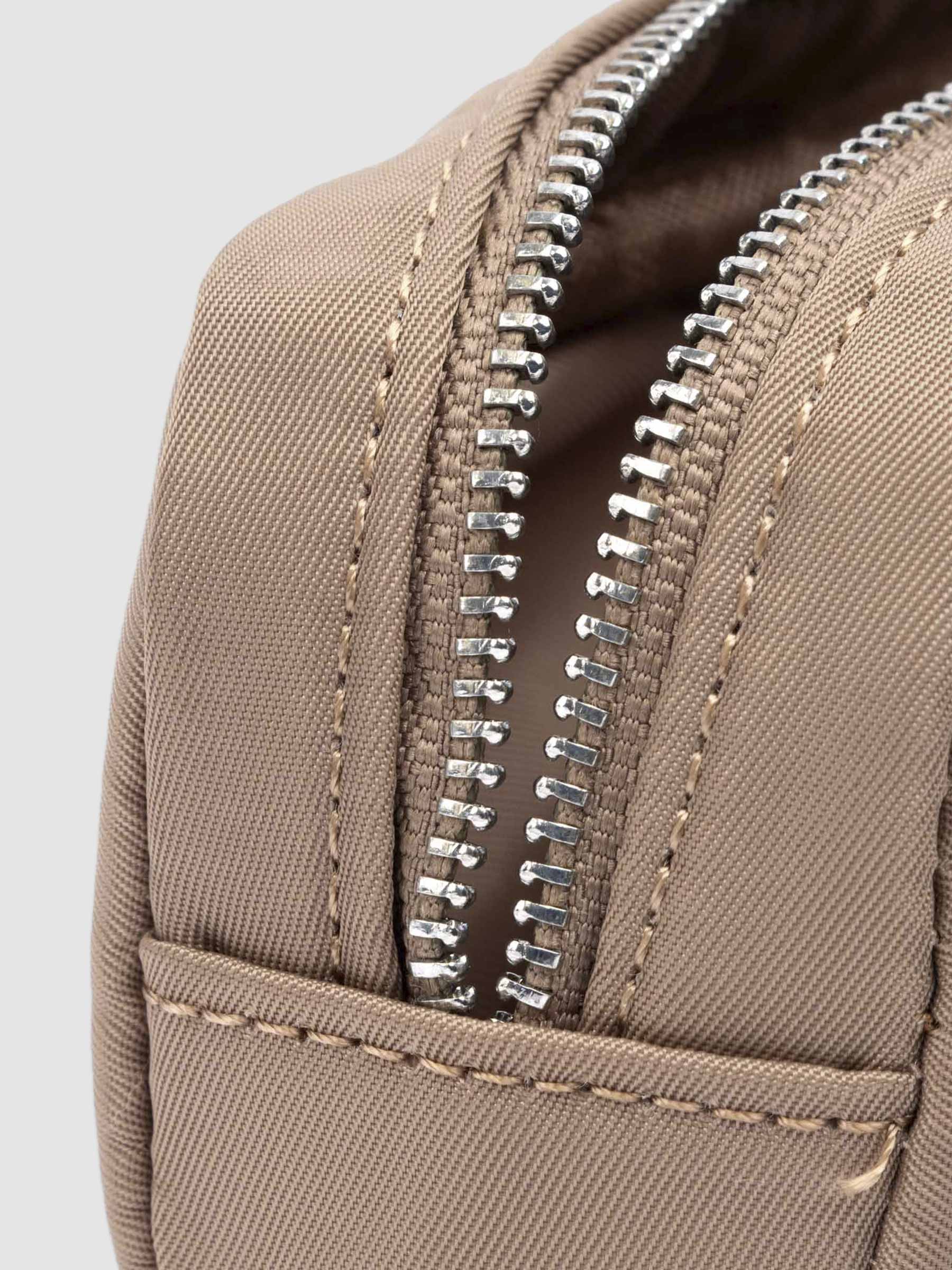 Closeup of pencil pouch's zipper. Color featured is fossil.