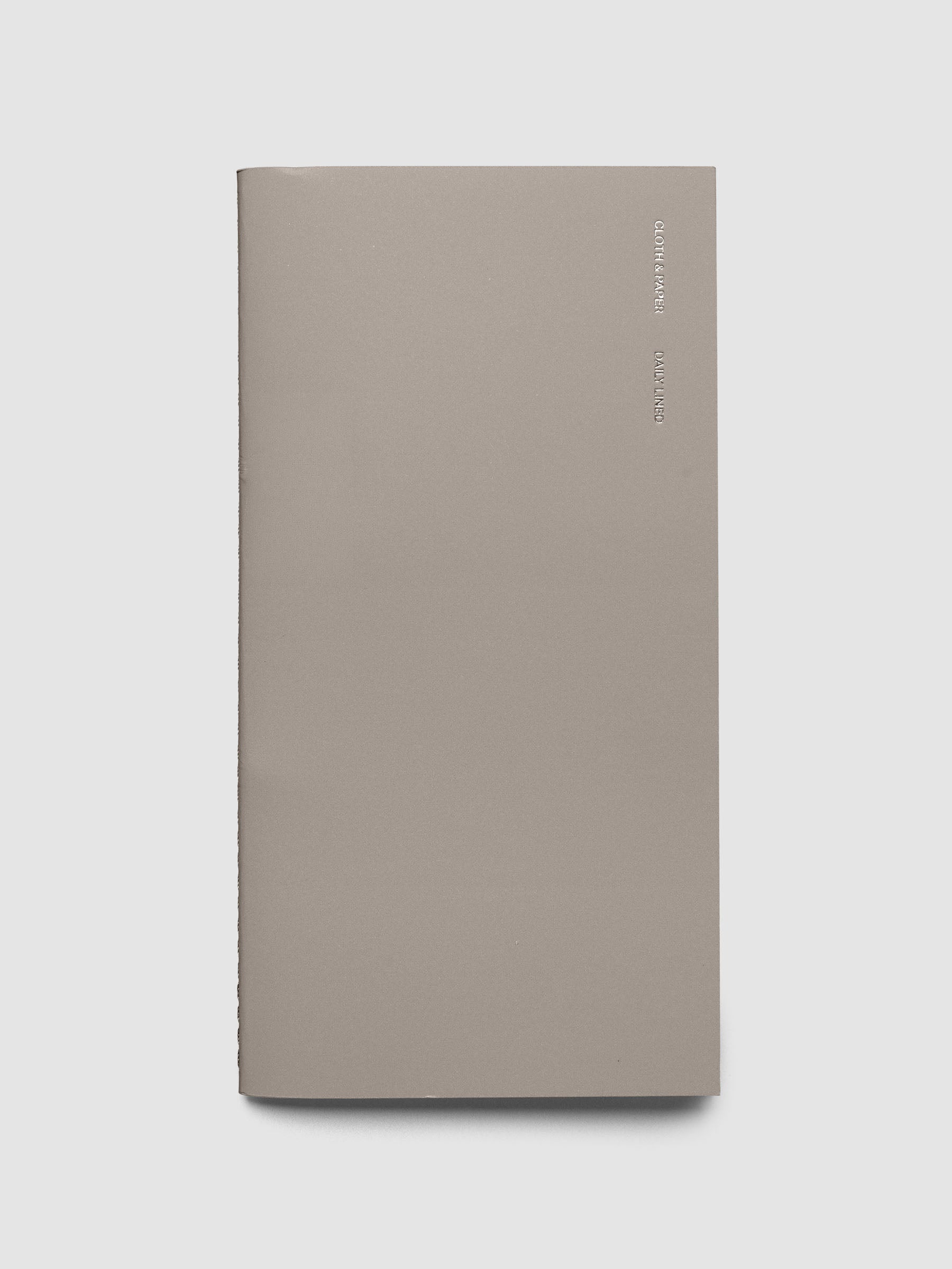 Travel Notebook in size A5 Slim in color Verona shown closed with silver foil CLOTH & PAPER DAILY LINED writing on the top right side.