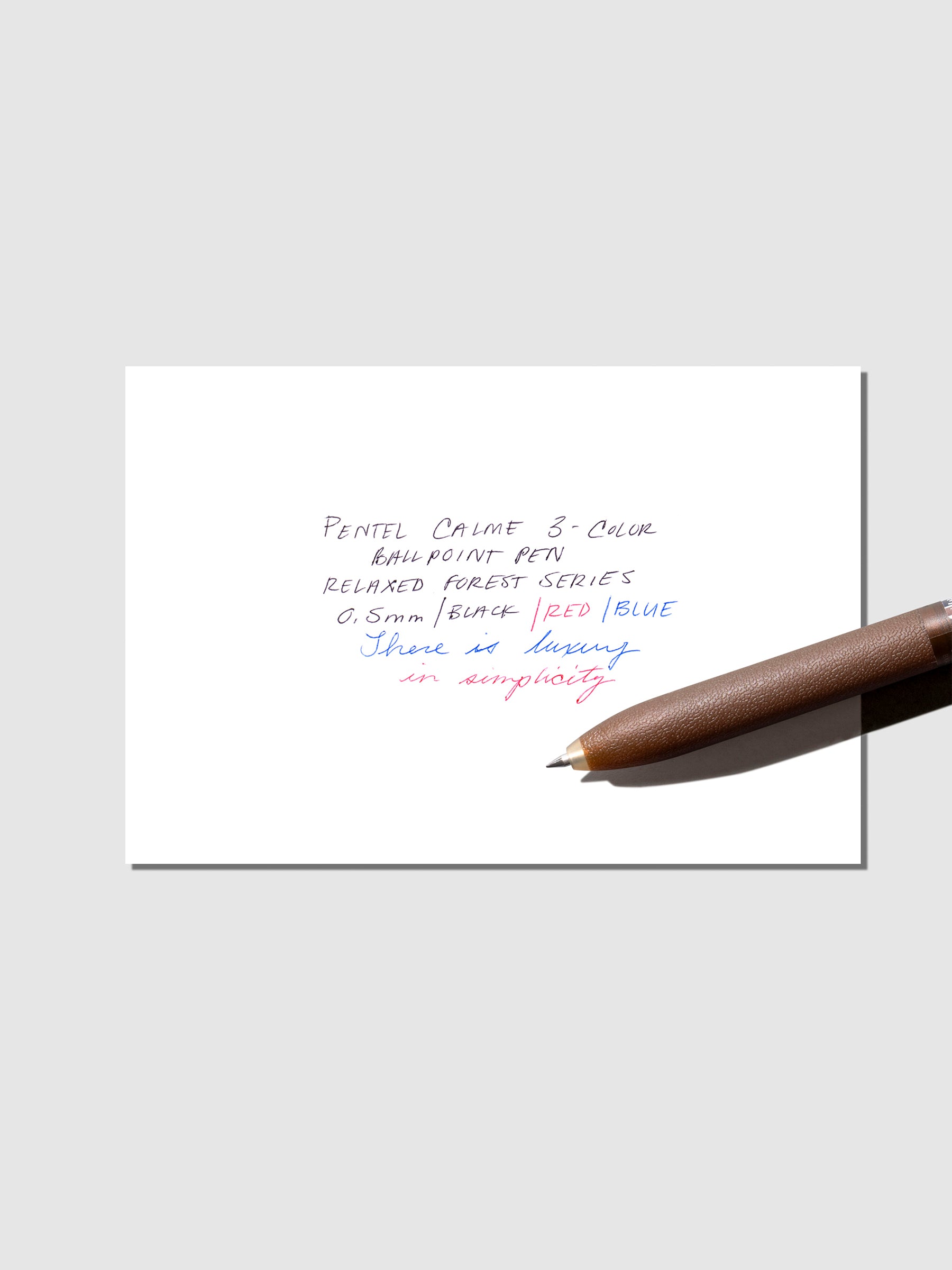 Pen test sheet shown with brown pen on a neutral background.