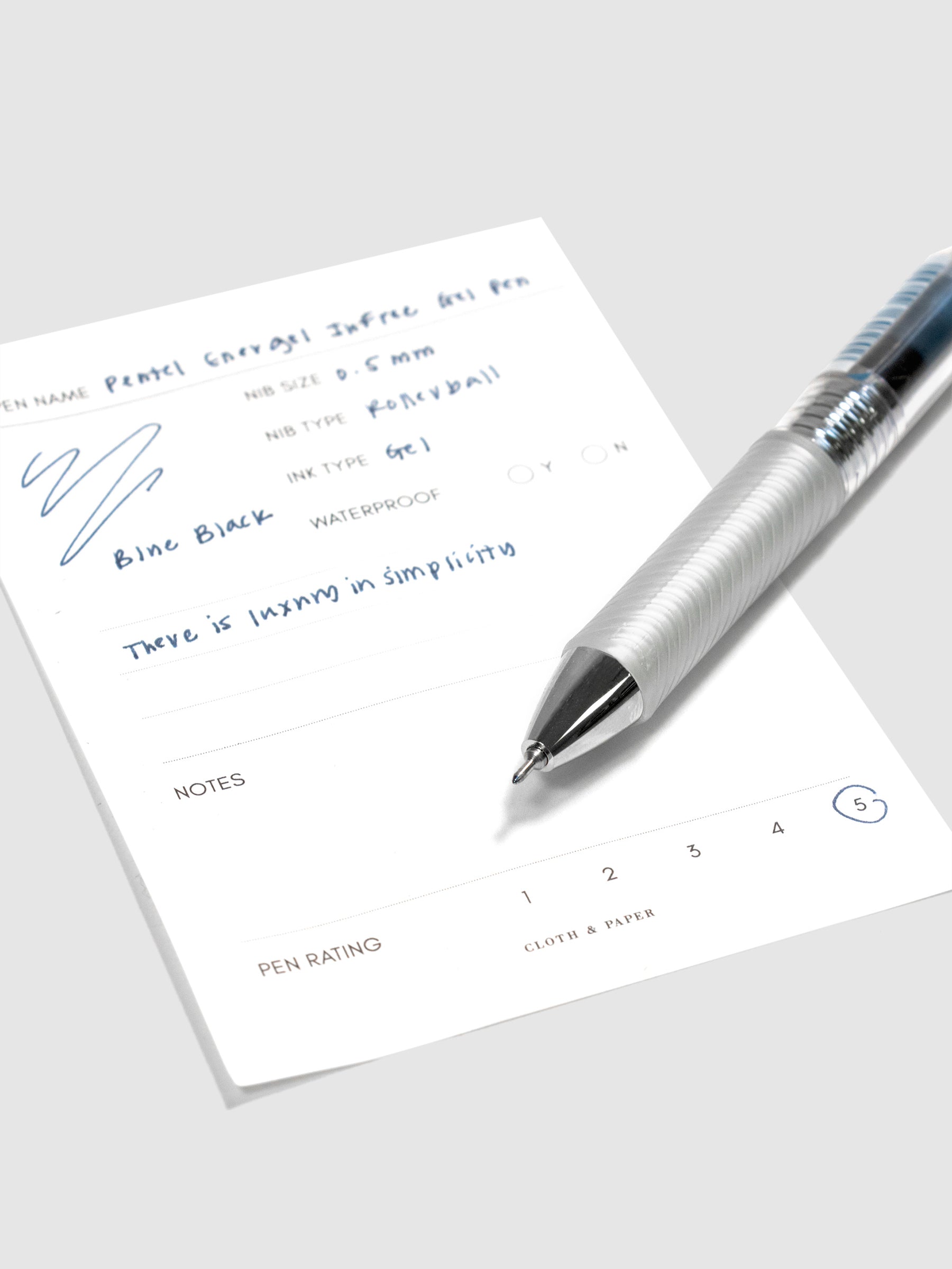 Pentel Energel Infree Gel Pen, Blue-Black, Cloth and Paper. Close up on pen nib resting on pen test sheet.