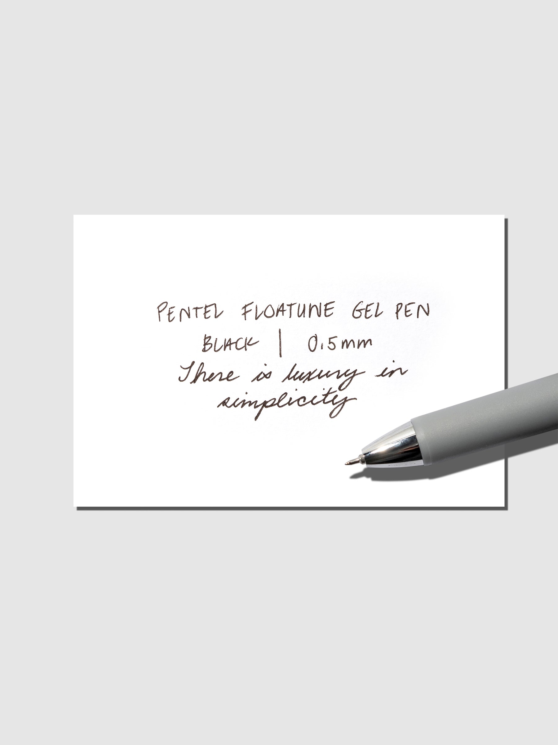 Pentel Floatune Gel Pen 0.5mm black ink. Pen resting on pen test sheet displaying writing sample.