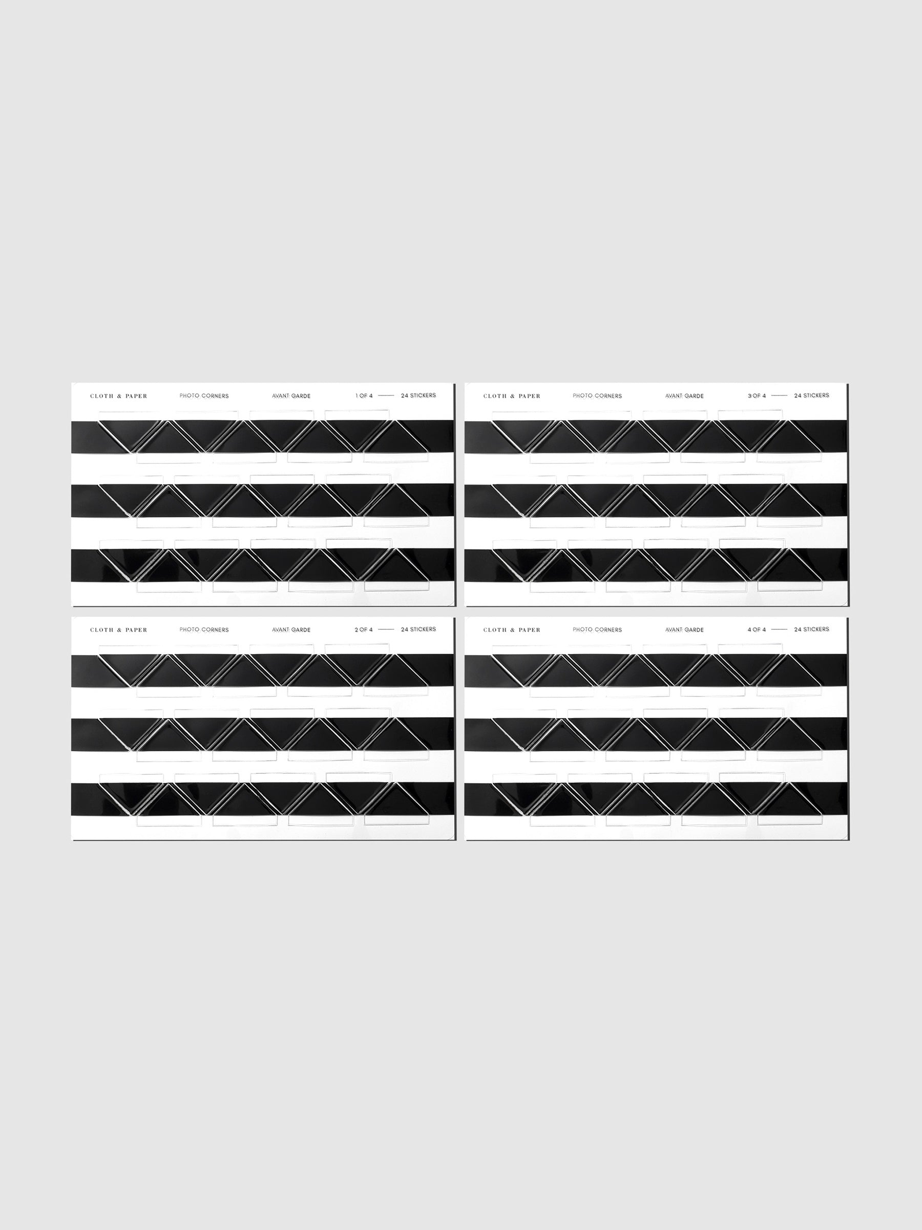 Four black photo corner sticker sheets displayed in their packaging on a neutral background.