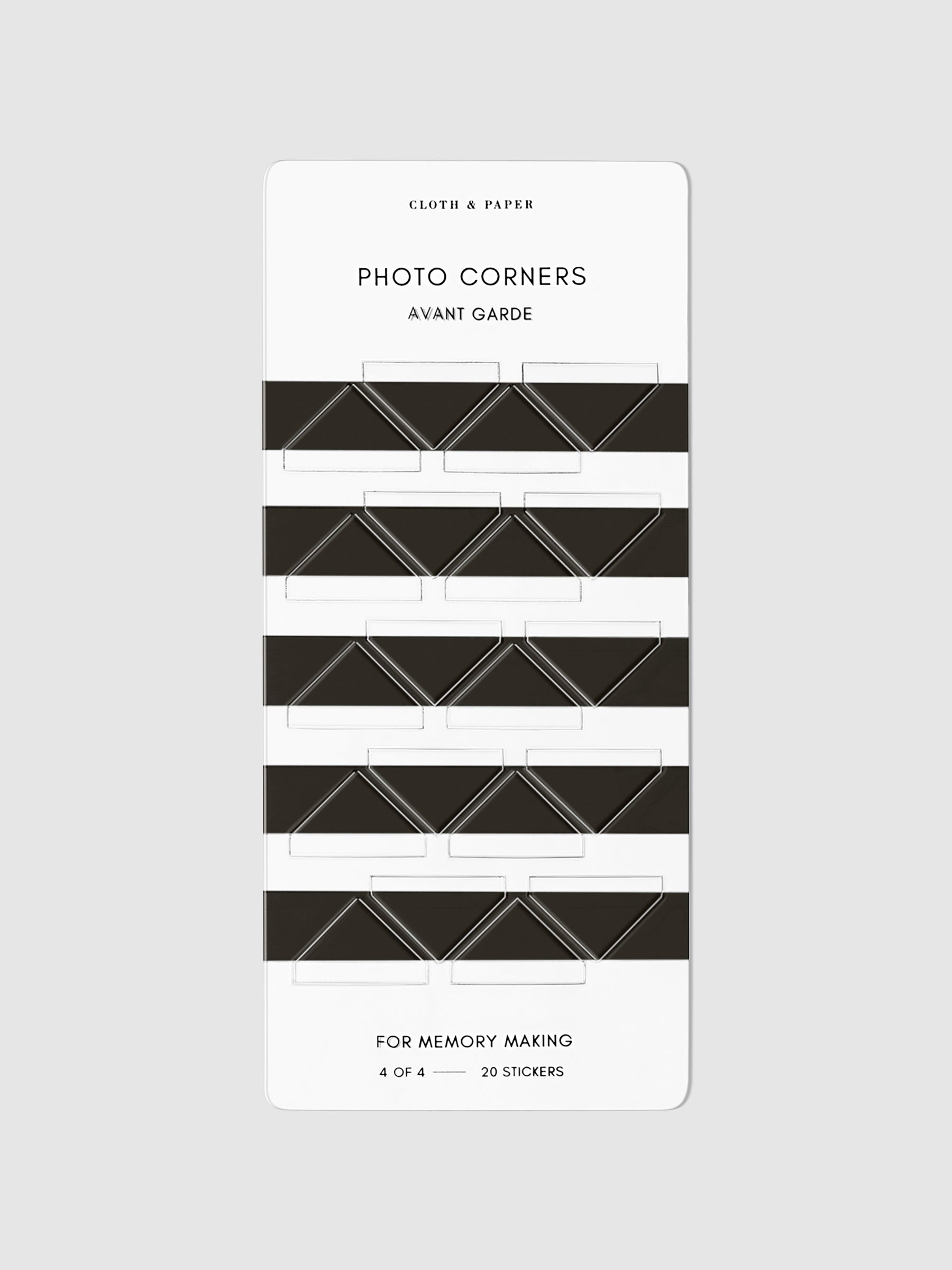 Black photo corners displayed on a neutral background.