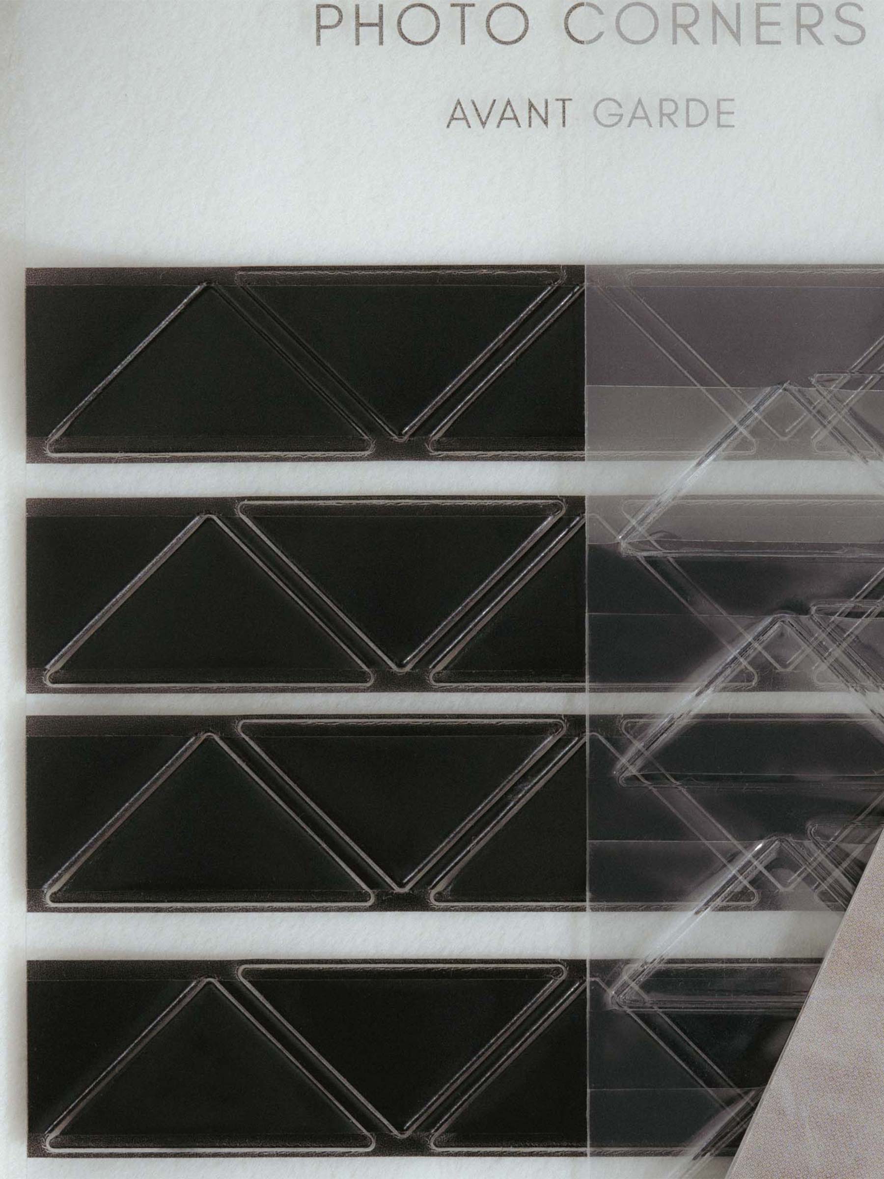 Several colors of Photo Corner stickers layered over each other on their backings.